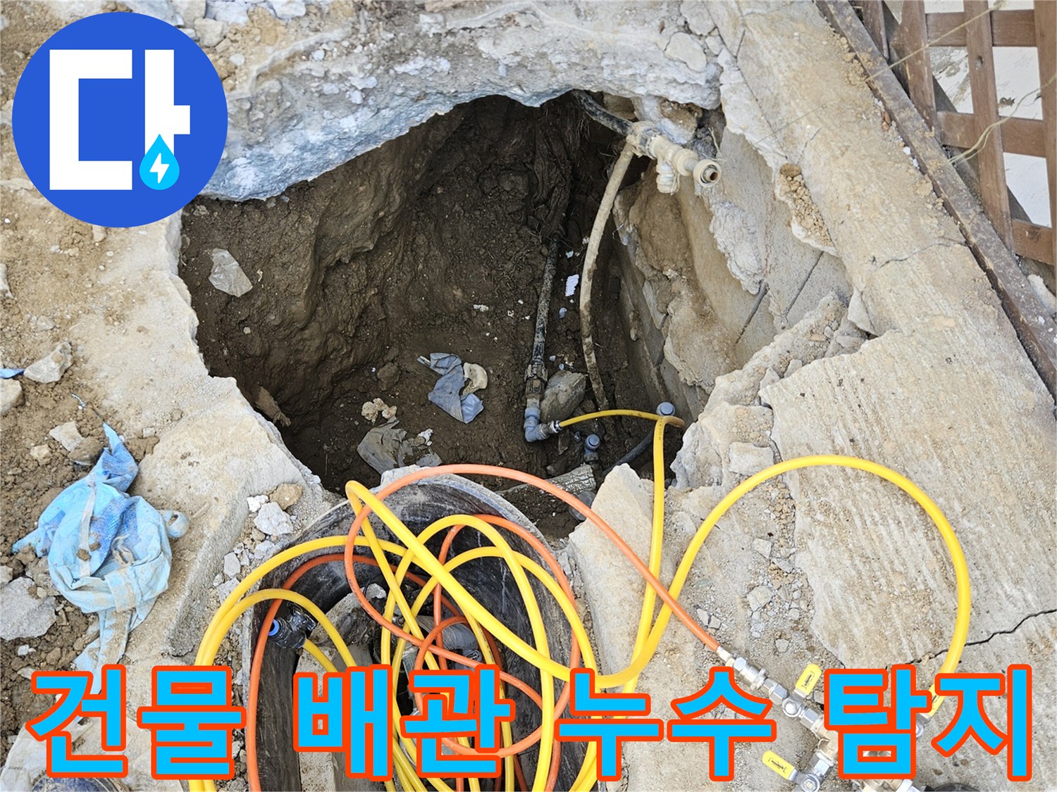 건물 내부 배관에서 발생한 누수 지점을 찾아내기 위해-땅을 파내고 전문 압력 테스트 장비를 설치하여-정밀하게 진단하는 작업 현장입니다.