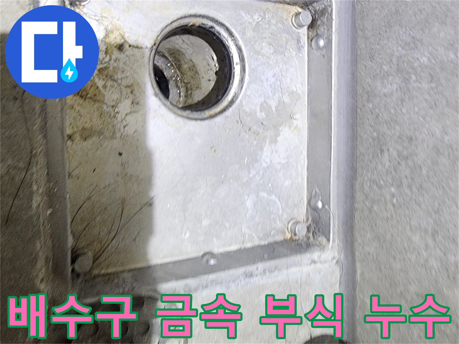 욕실 배수구의 금속 부분에-발생한 부식과 오염을 통해-누수 발생 여부를-면밀히 확인하는-현장 점검 사진입니다