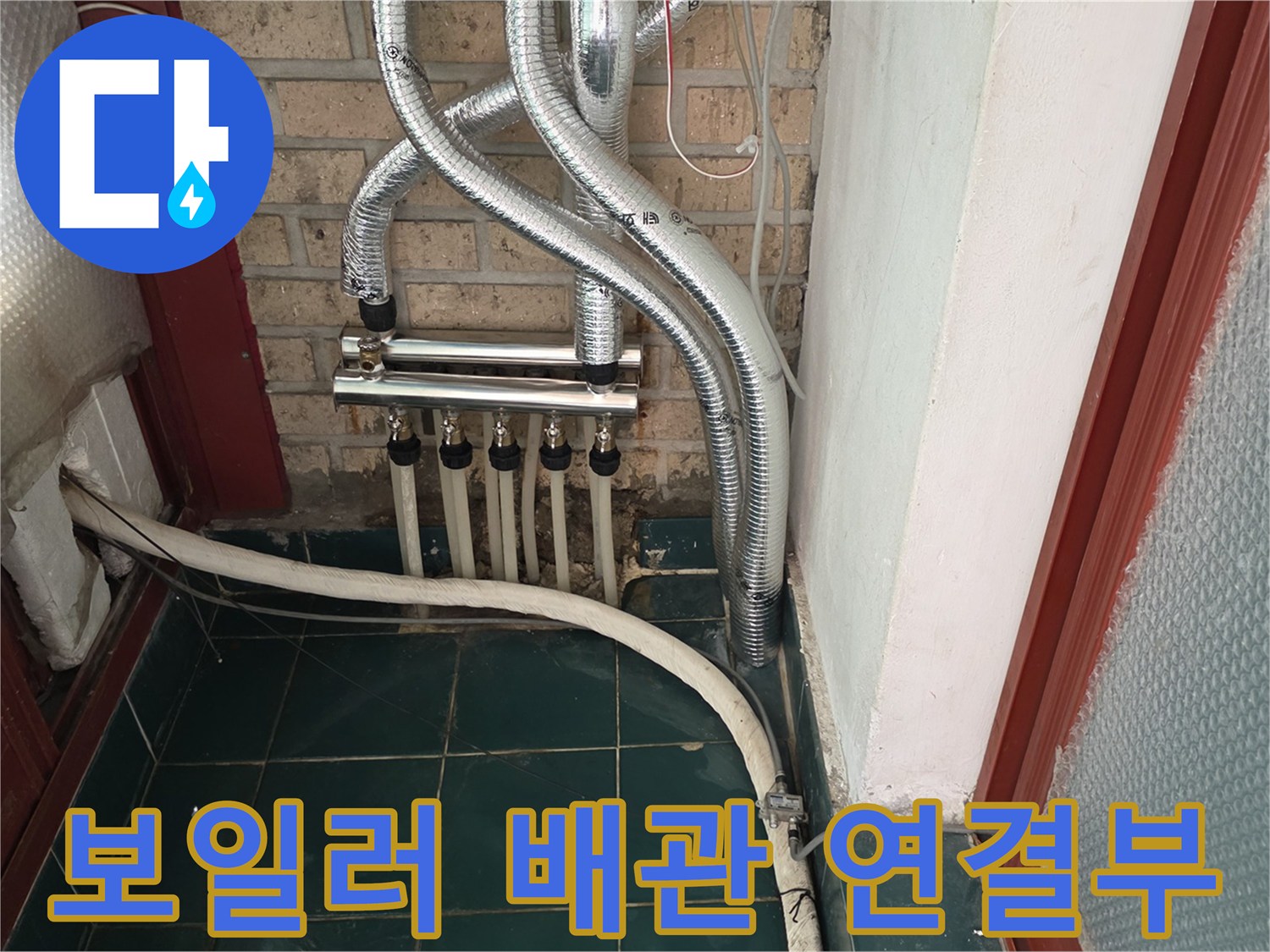 보일러실 벽면에 설치된 은색 배관과 하단 분배기 상세 사진입니다.
