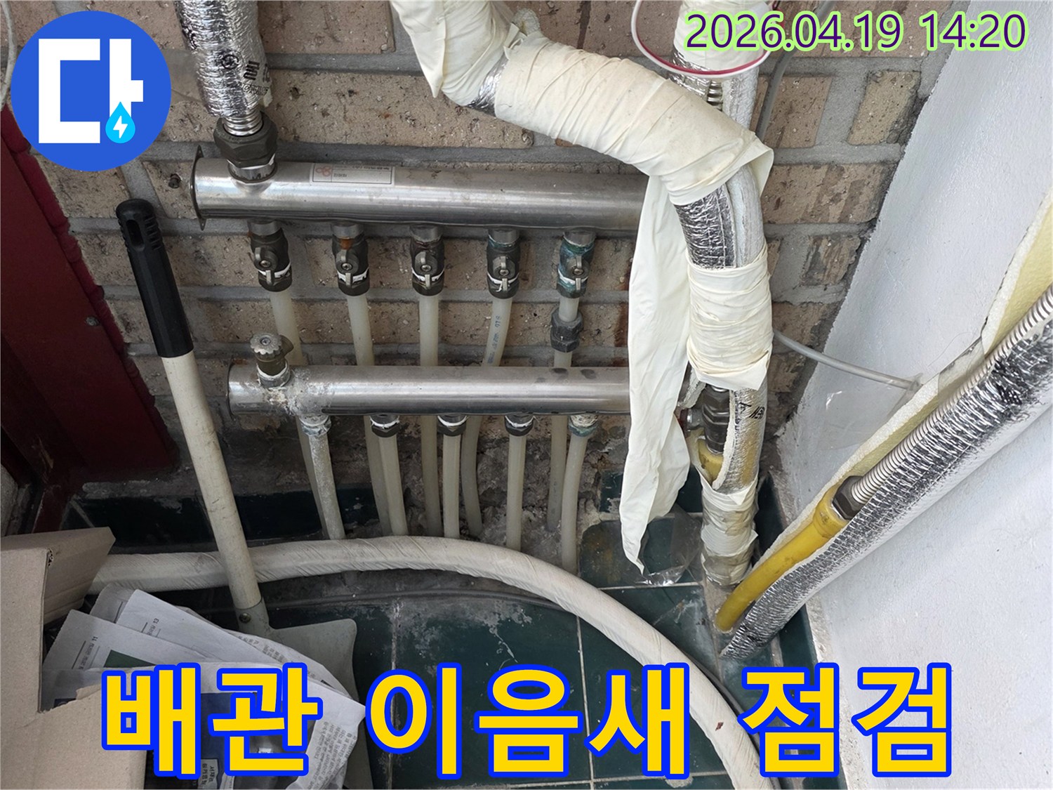 오래된 아파트의 배관 이음새 부분에서 누수 징후를 면밀히 점검하는 전문적인 현장