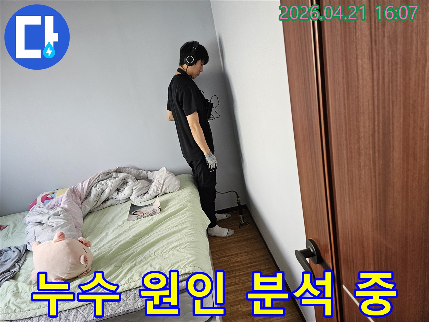 누수-탐지-전문가가-헤드폰을-착용하고-벽에-귀를-기울여-미세한-누수-소리를-듣고-있습니다