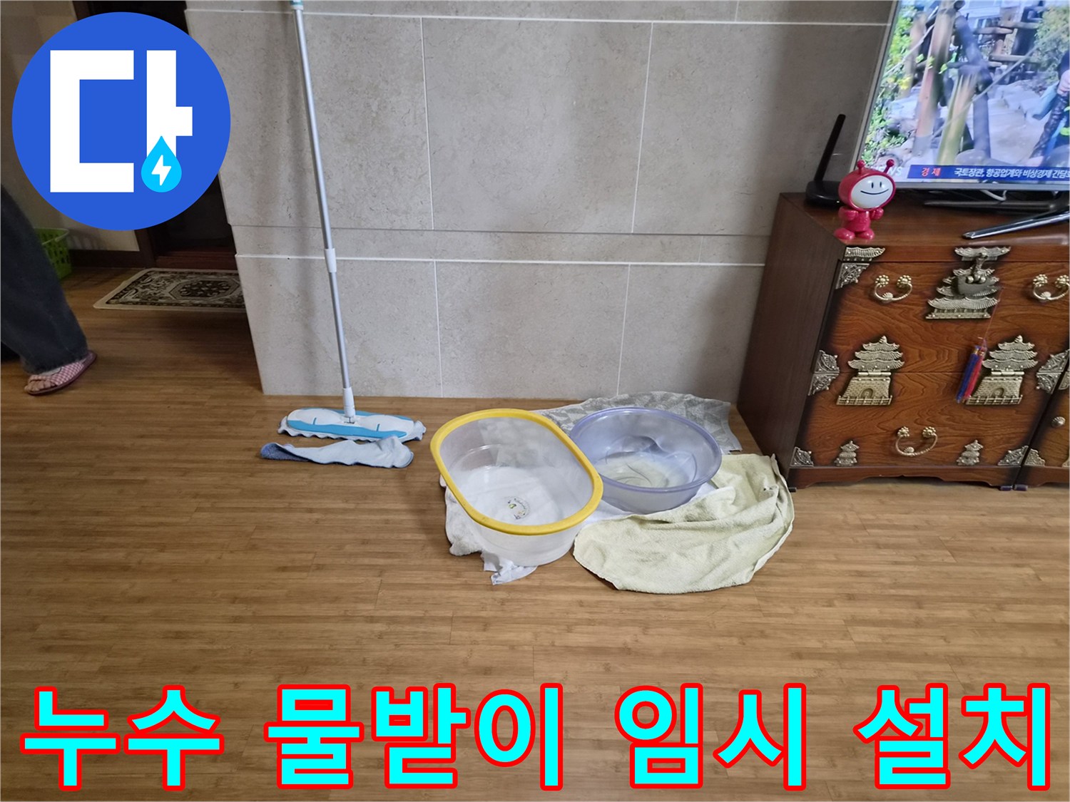 누수로 인해 바닥에 물이 떨어지는 것을 막기 위해 대야와 걸레를 놓은 모습-주택 내부의 물샘 현장에 대한 긴급 조치
