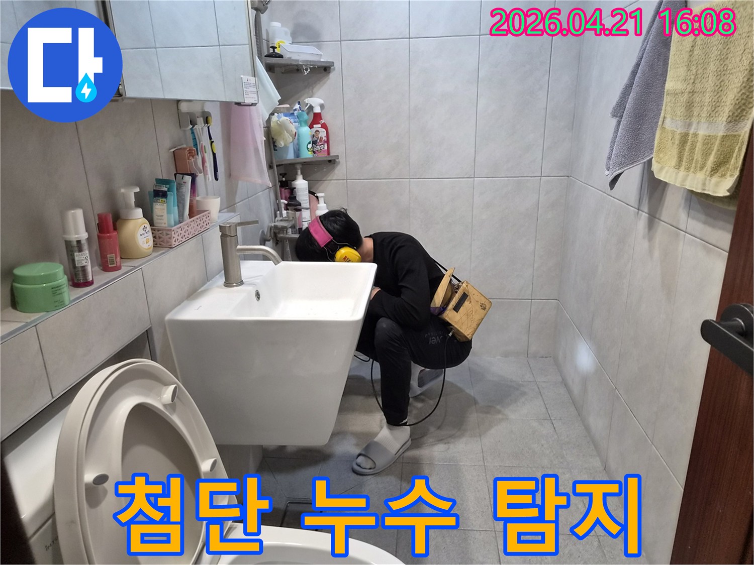 전문 엔지니어가 욕실에서-첨단 청음 장비를 이용해-배관의 미세한 누수음을 꼼꼼하게 듣고-누수 지점을 찾아내고 있습니다