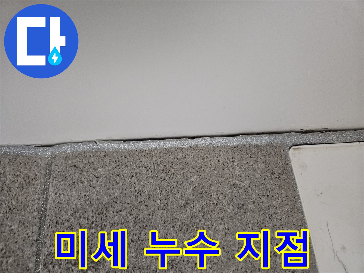 오산 부산동 누수 현장에서 누수 엔지니어가 벽면과 바닥 사이의 미세 누수 지점을 확인하고 있습니다.