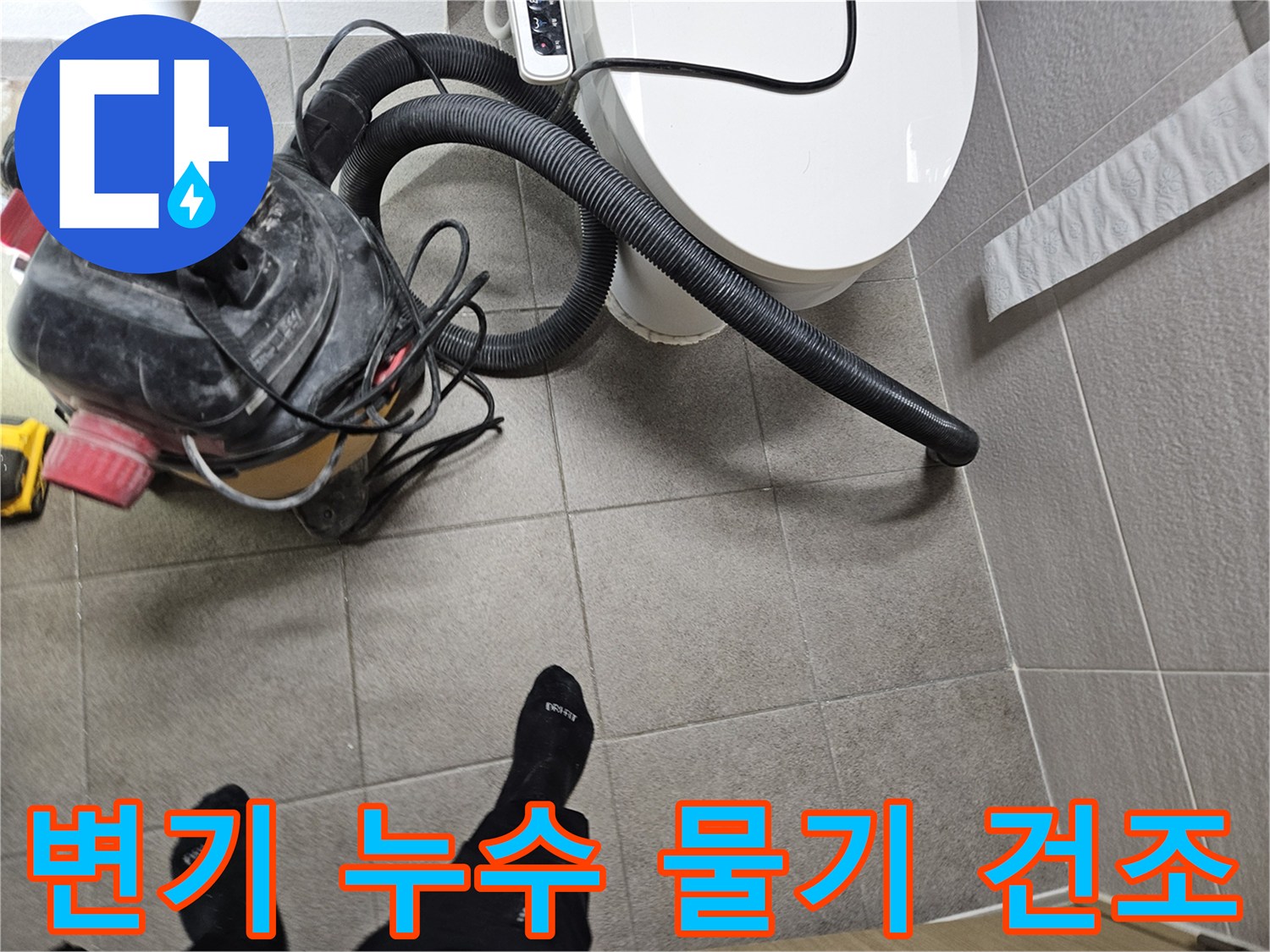 오산시 고객 댁 화장실에서-누수 엔지니어가-변기 주변의 물기를-습식 청소기로 제거하며-누수탐지를 위한-바닥 건조 작업을 진행하는 모습