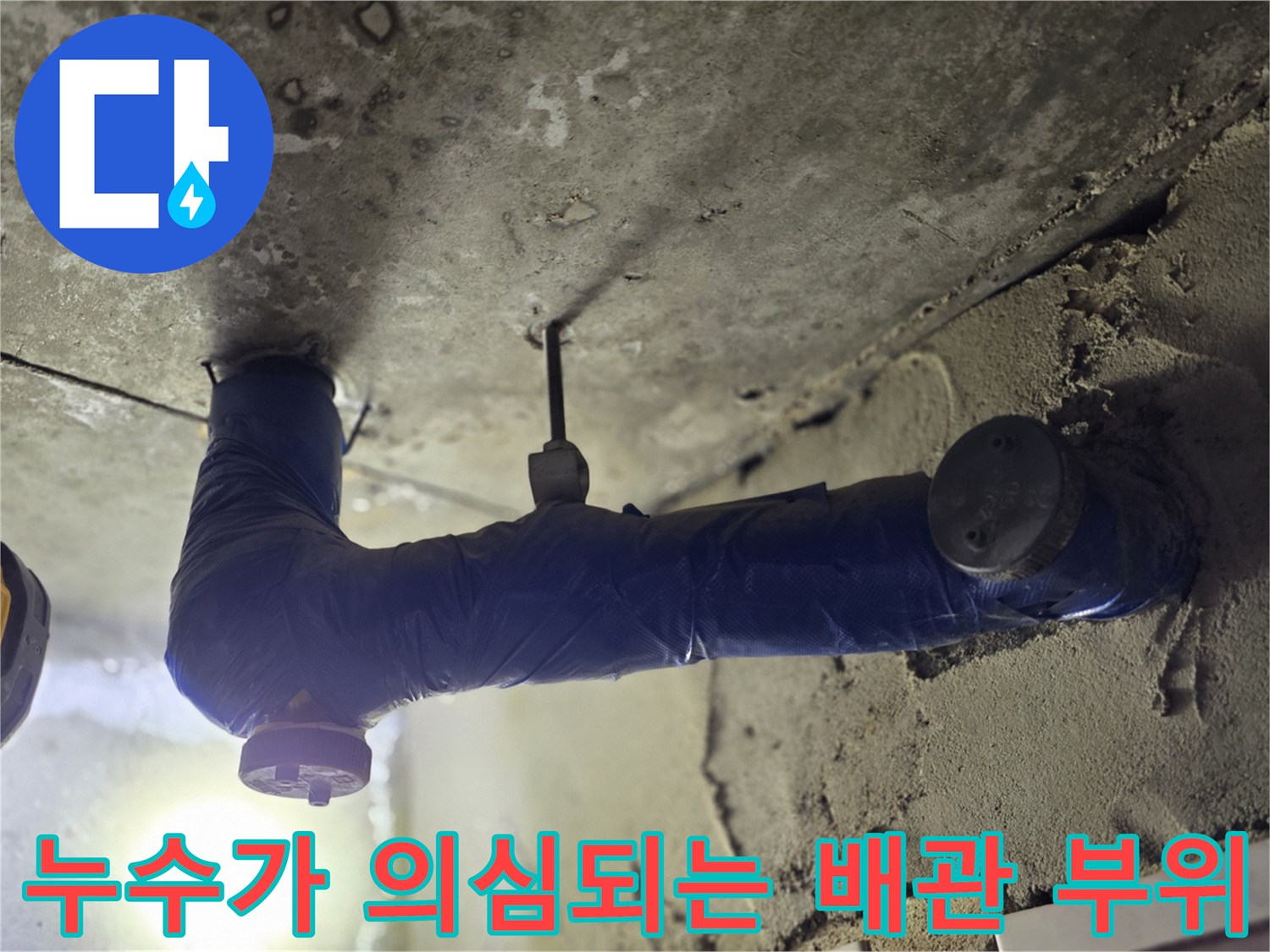 천장 내부 파란색 보온재로 감싸진 굴곡진 배관의 근접 사진