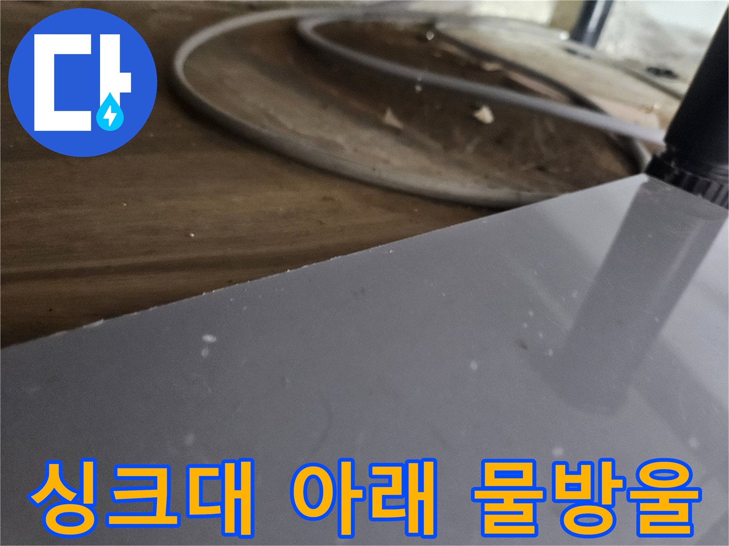 싱크대-아래-바닥에-고인-물을-발견하고-누수-발생-지점을-육안으로-점검하는-상황