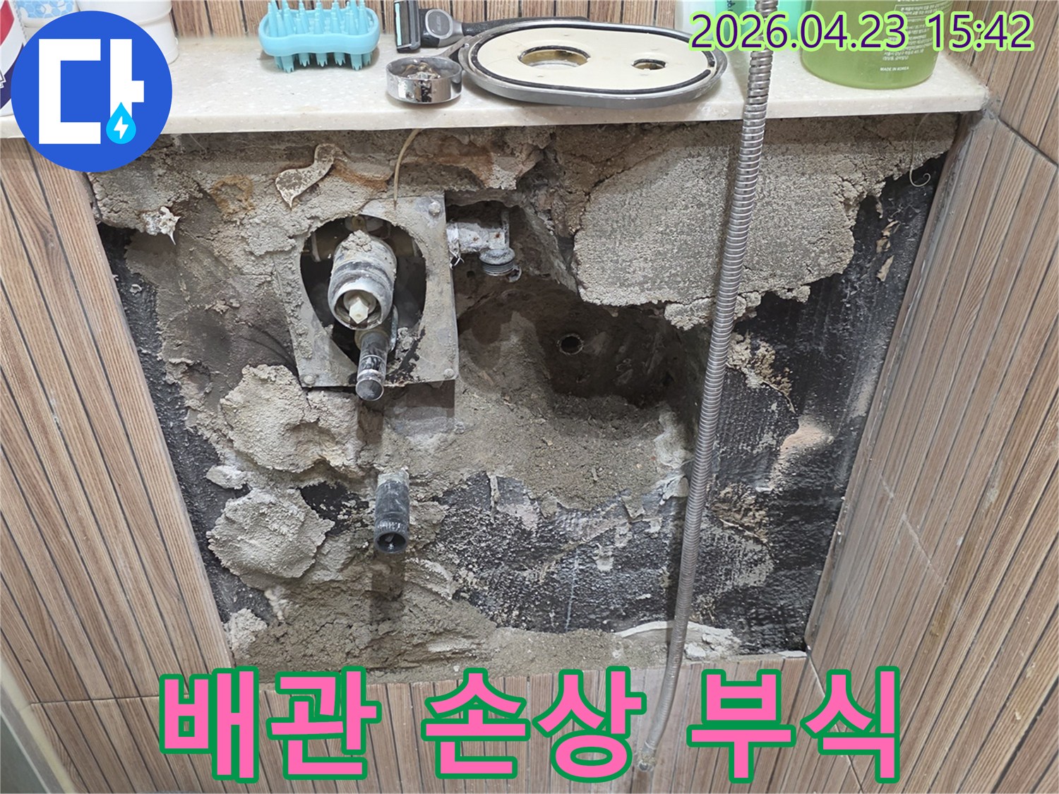 노원구 상계동 아파트 화장실 누수 현장에서-벽체를 개방하고-내부 배관의 손상 및 부식 상태를 보여주는 사진입니다.