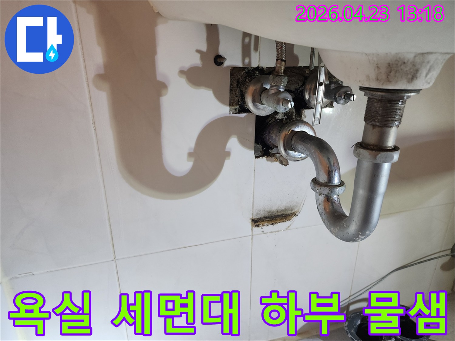 이 사진은 양주 지역 아파트 욕실 세면대 아래 배관에서 발생한-지속적인 물샘으로 인한 벽면 오염 상태를 보여줍니다.