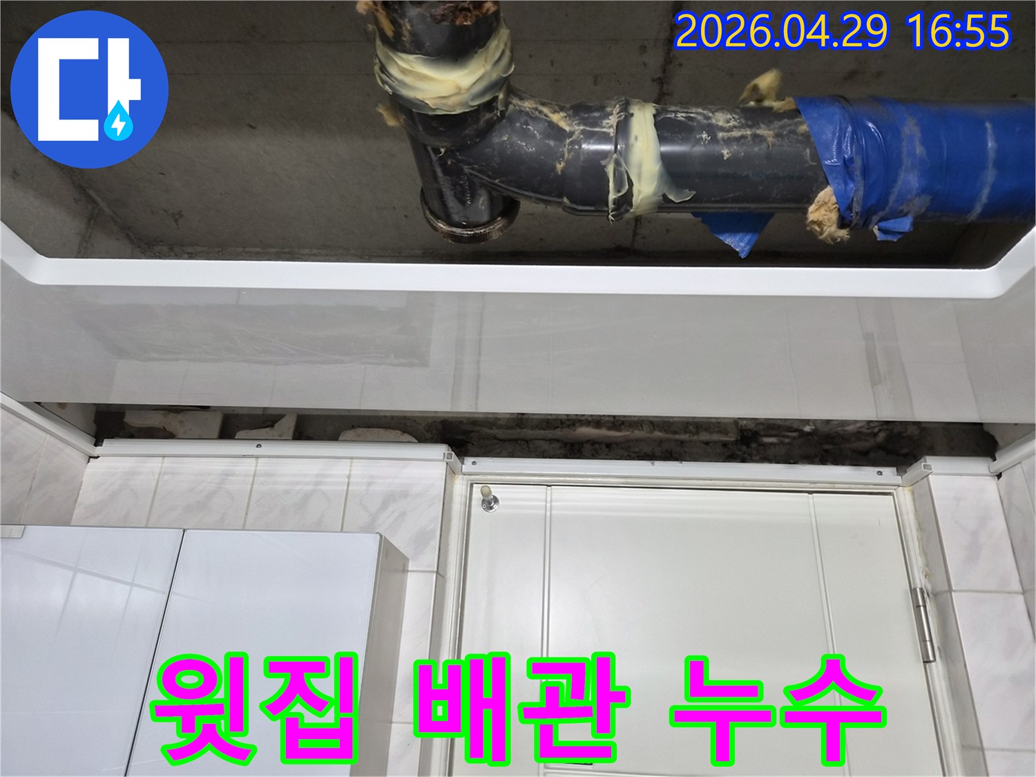 도봉구 아파트에서-윗집 배관 누수로 인해-아랫집 천장에 피해를 준-현장 사진입니다-손상된 배관 이음새에-임시 보수 흔적이 보입니다.