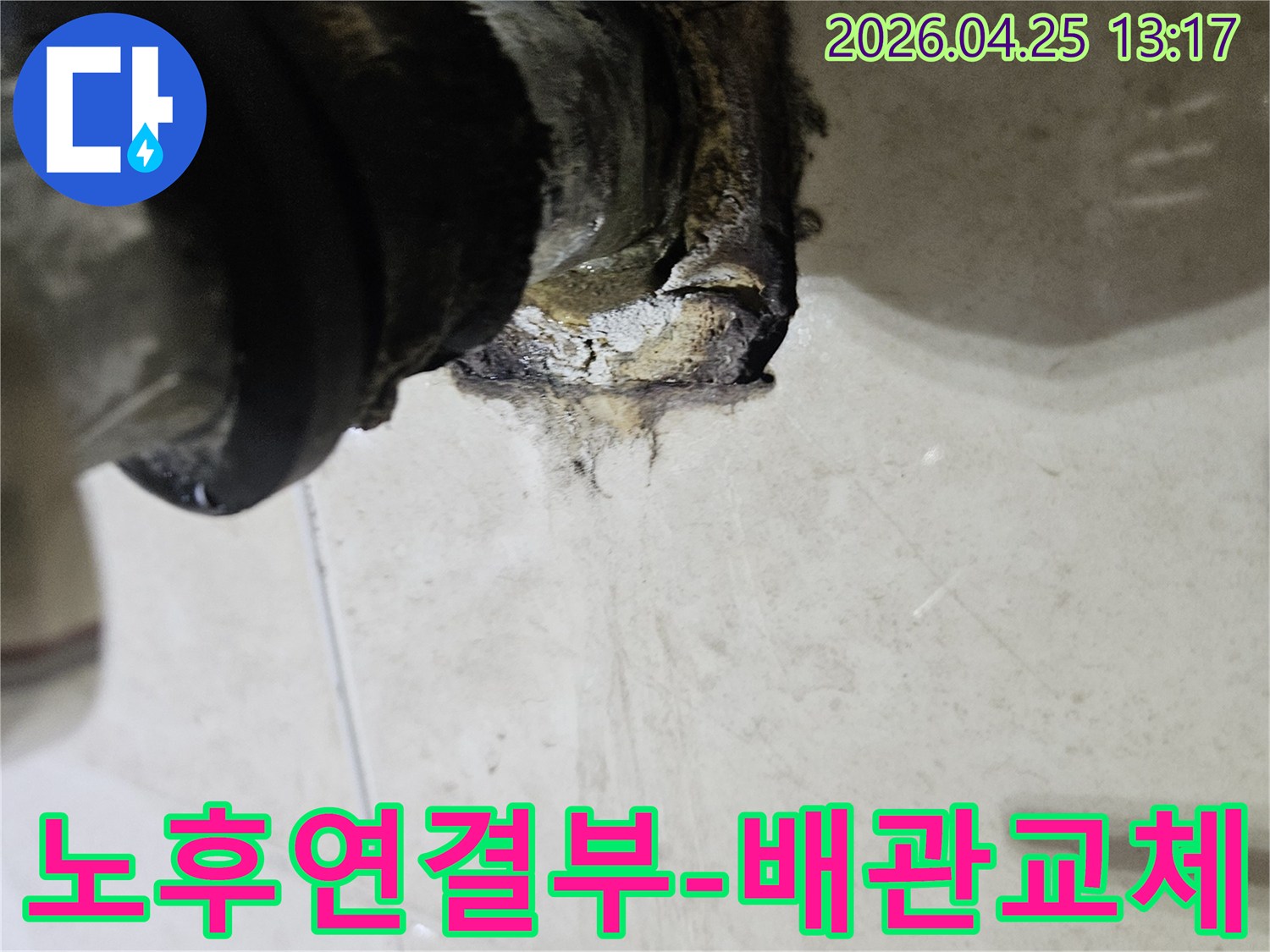 오래되고 노후화된 배관 연결 부위에서 누수가 발생하여 주변이 심하게 손상된 모습을 보여주는 이미지입니다-노후화된 연결부 교체가 시급합니다.