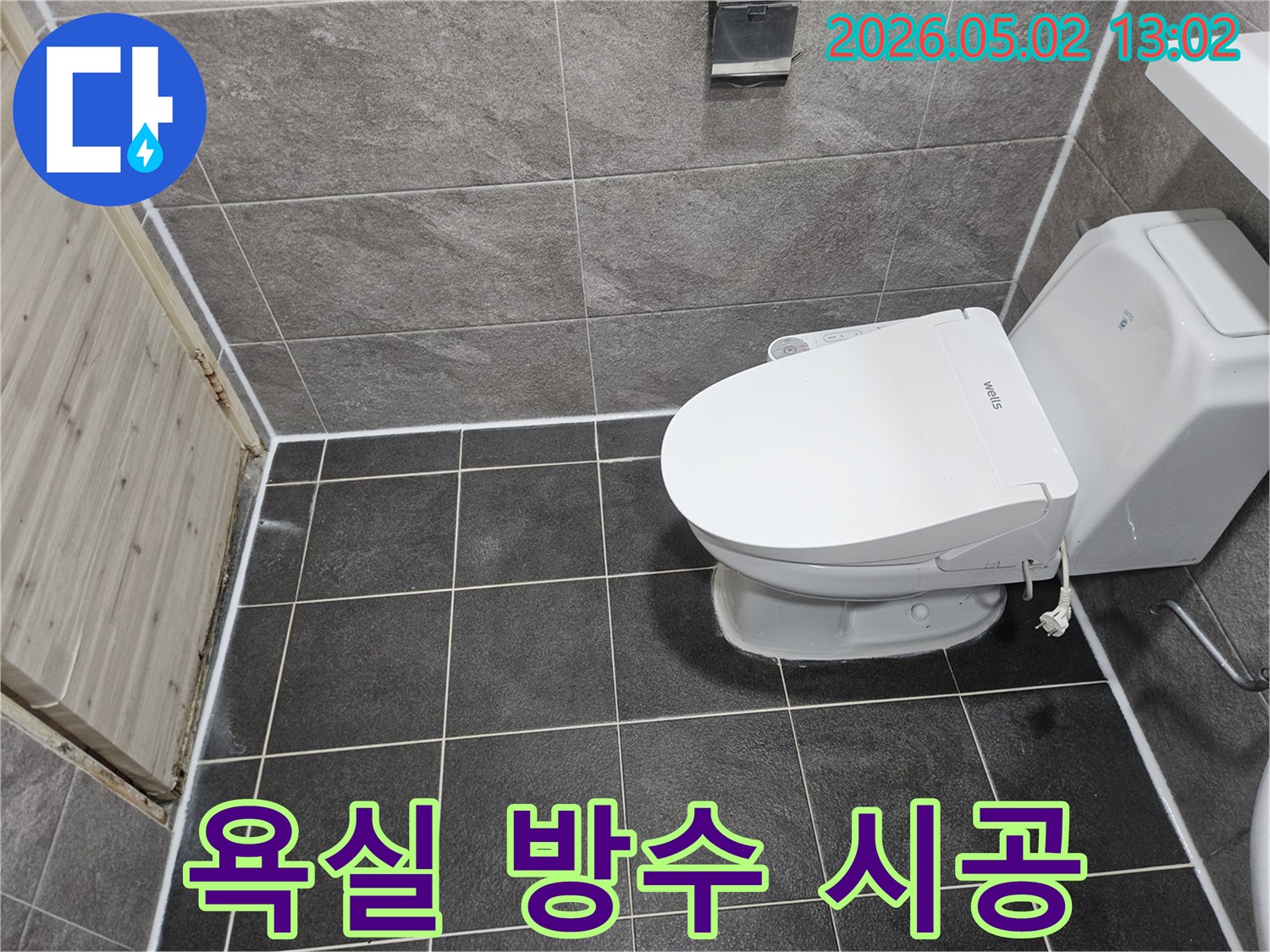 이 이미지는 욕실 바닥과 벽 타일-그리고 변기 주변의 이음새에 새로 적용된 깨끗한 실리콘 코킹 마감 상태를 보여줍니다.