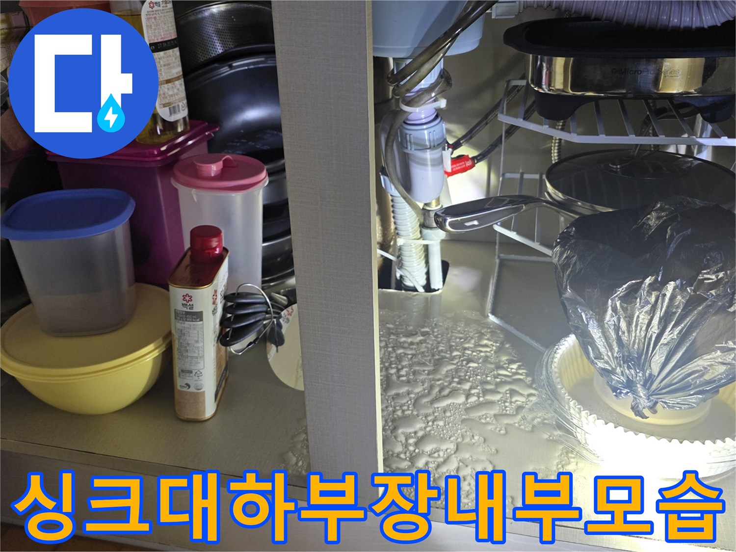 누수 진단을 위해 개방한 싱크대 하부장 내부의 배관 구조