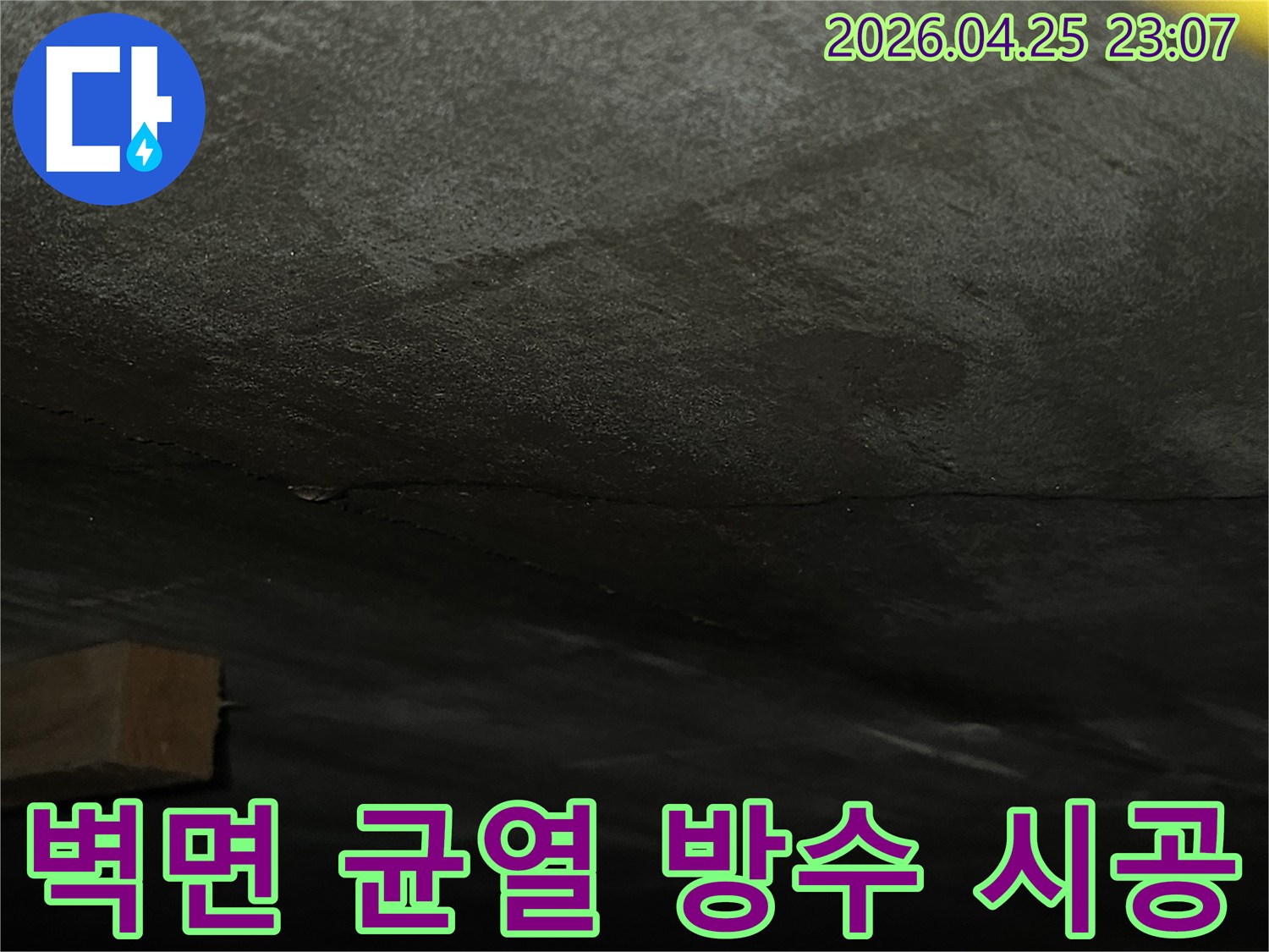 어두운-벽면에-발생한-수직-균열을-확인하고-누수-공사를-준비하는-현장-사진