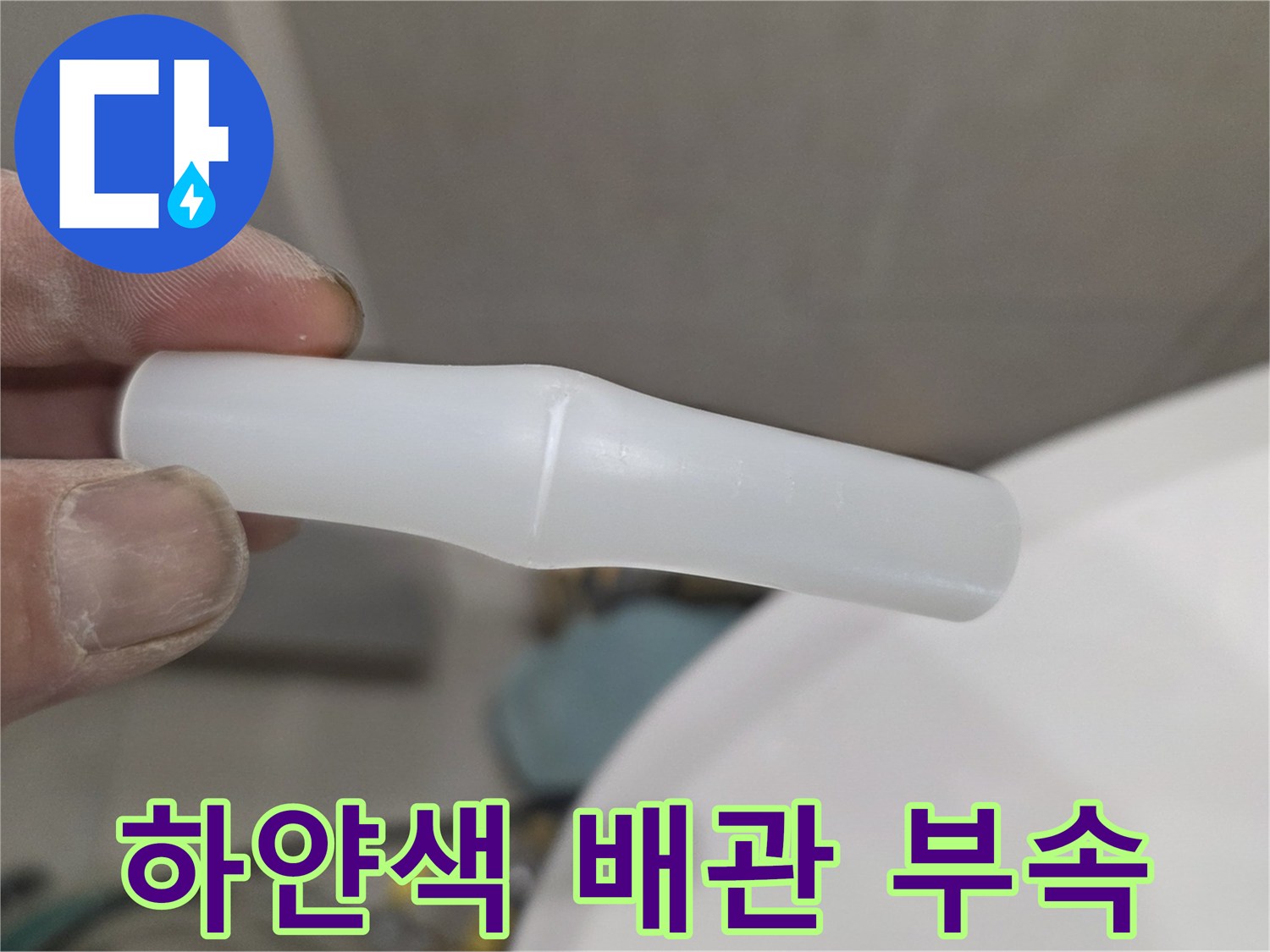 손가락으로 잡고 있는 파손된 흰색 플라스틱 배관 연결 소켓