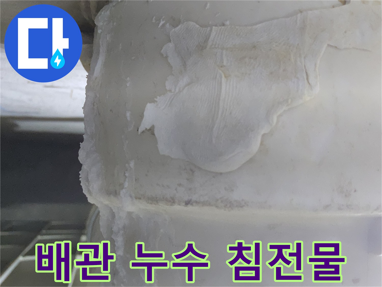 누수 지점에서-발견된-하얀색의-결정화된-물 침전물과-오염된-천 조각이-함께 보이는-모습입니다.
