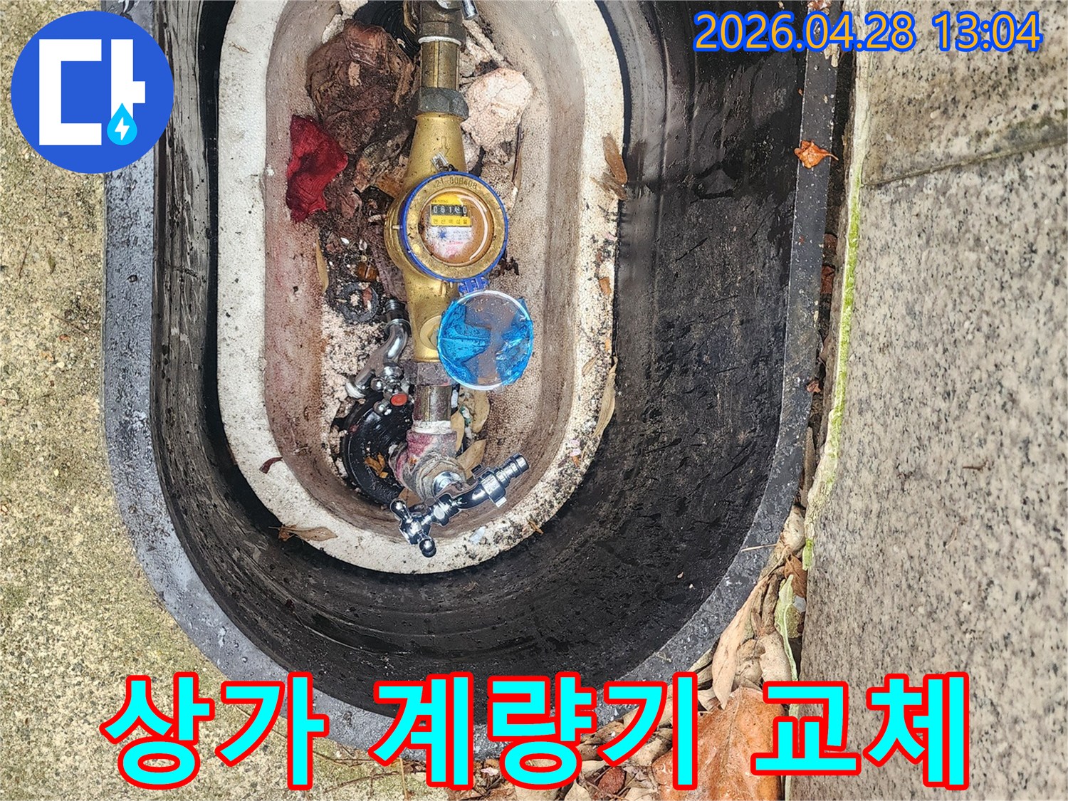 상가 건물 외부 수도계량기함 내부의 노후된 배관을 점검하고-교체 작업을 위해 준비하고 있습니다.
