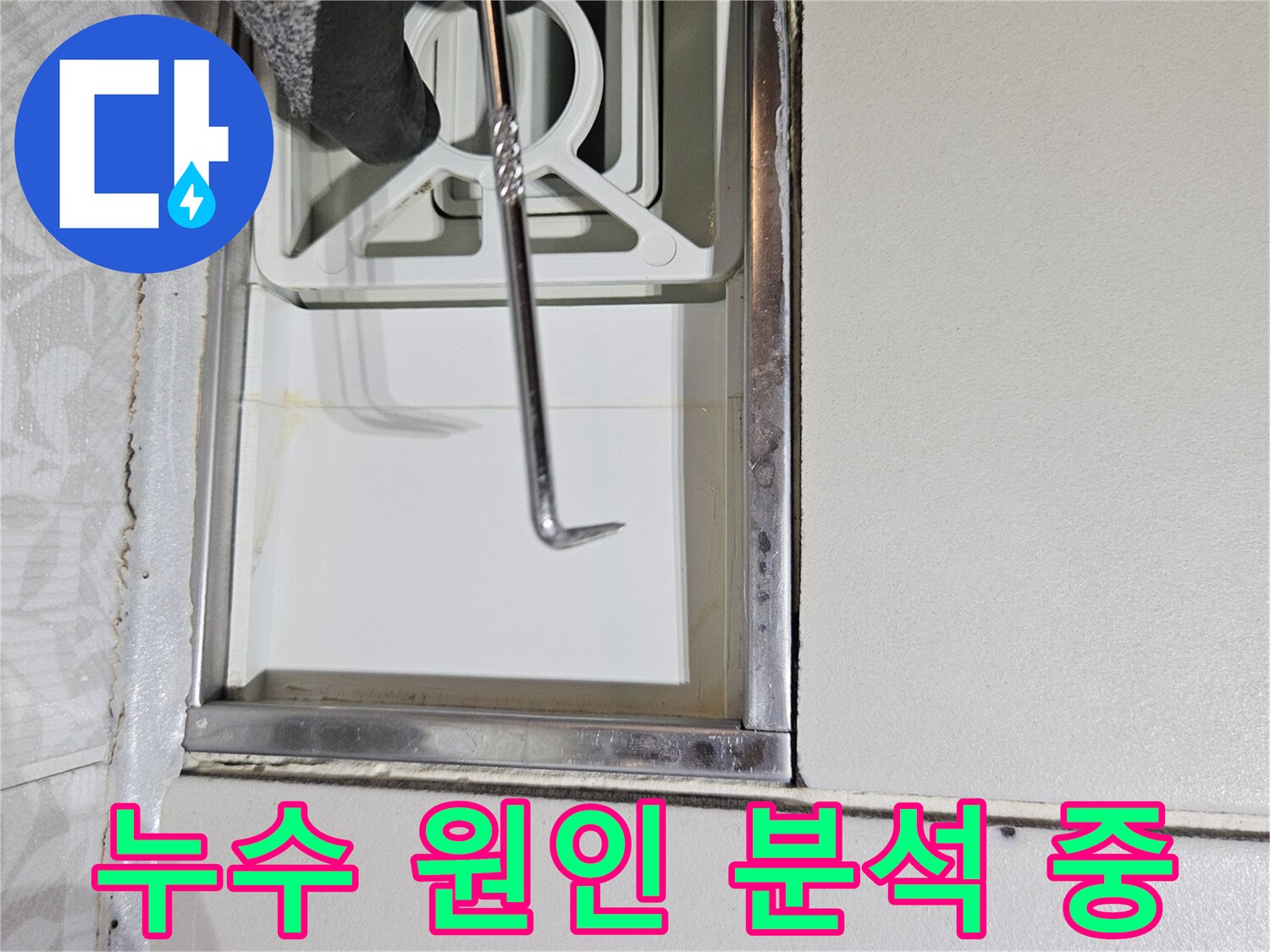 누수 전문 기술자가-특수 도구로-벽면 틈새를-정밀하게-조사하며-누수 원인을-분석하는 장면입니다