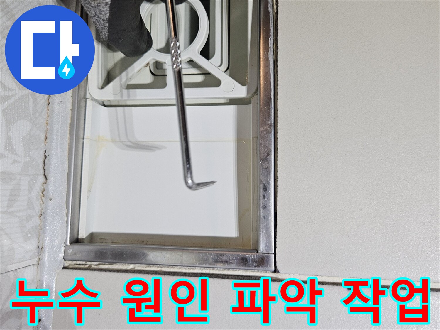 누수 전문 기술자가-특수 도구로-벽면 틈새를-정밀하게-조사하며-누수 원인을-파악하는 장면입니다