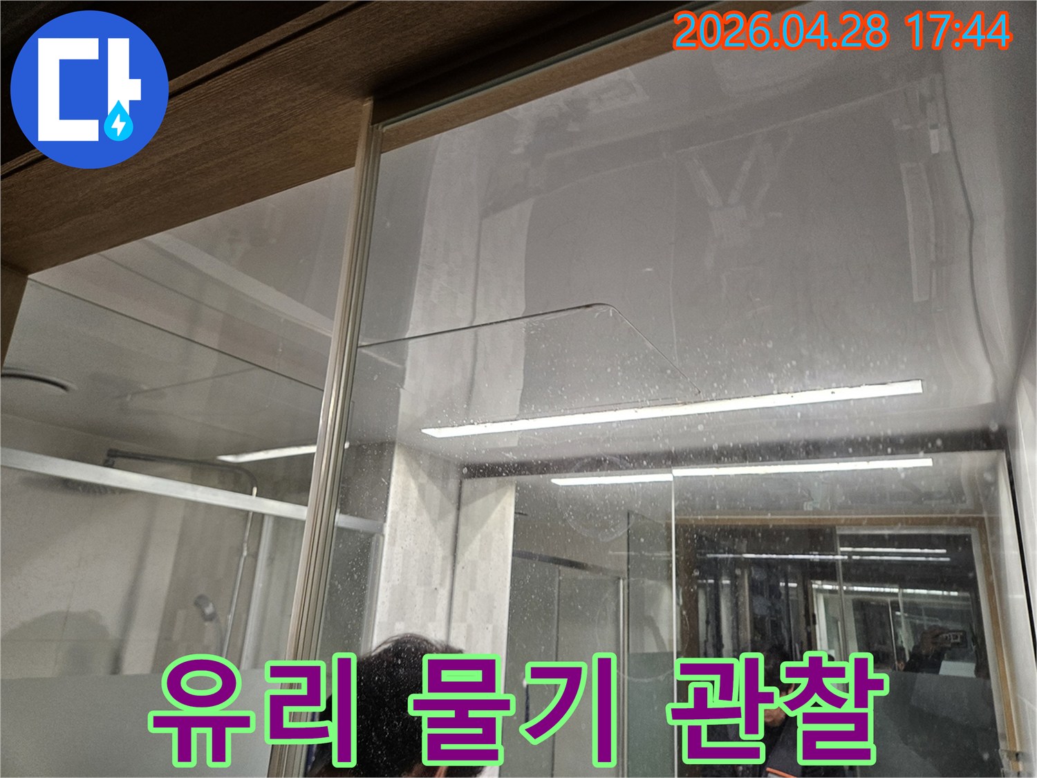 유리-벽면에-맺힌-물방울과-바닥의-물-자국-누수-전문가가-현장에서-누수-진단을-시작하는-모습