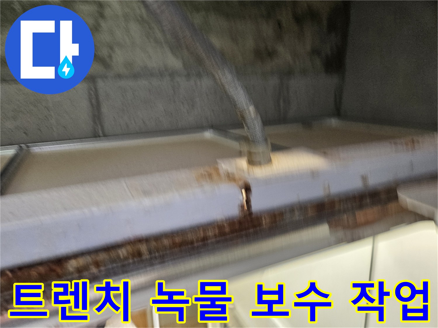 이 이미지는-베란다 배수 트렌치의-녹물 제거와-보수 작업을-보여줍니다-누수 전문가가-꼼꼼하게-처리하고-있습니다.