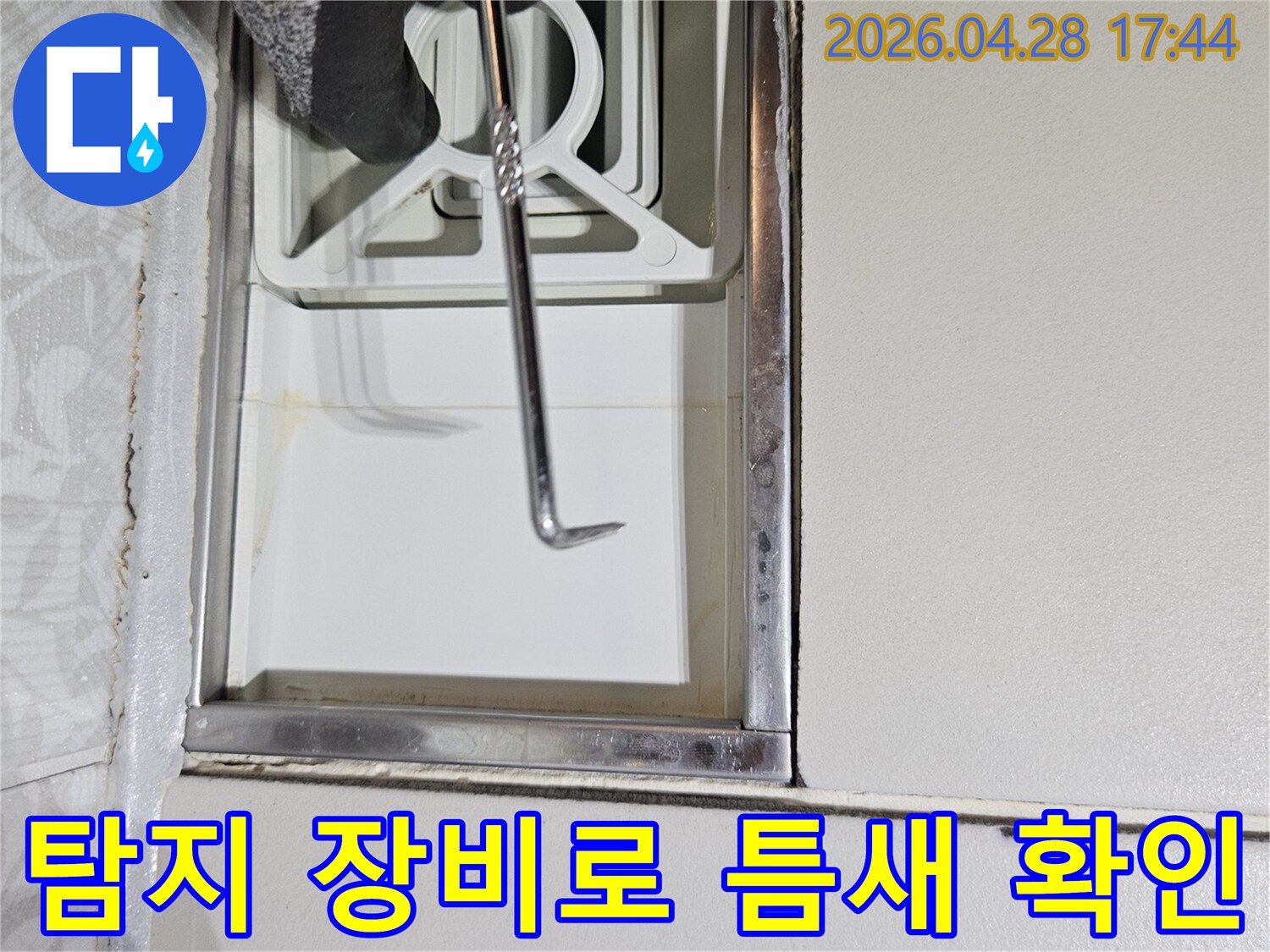 전문 누수 탐지사가-특수 제작된 도구로-벽면 하단부의-작은 틈새를-세밀하게-조사하는 모습입니다