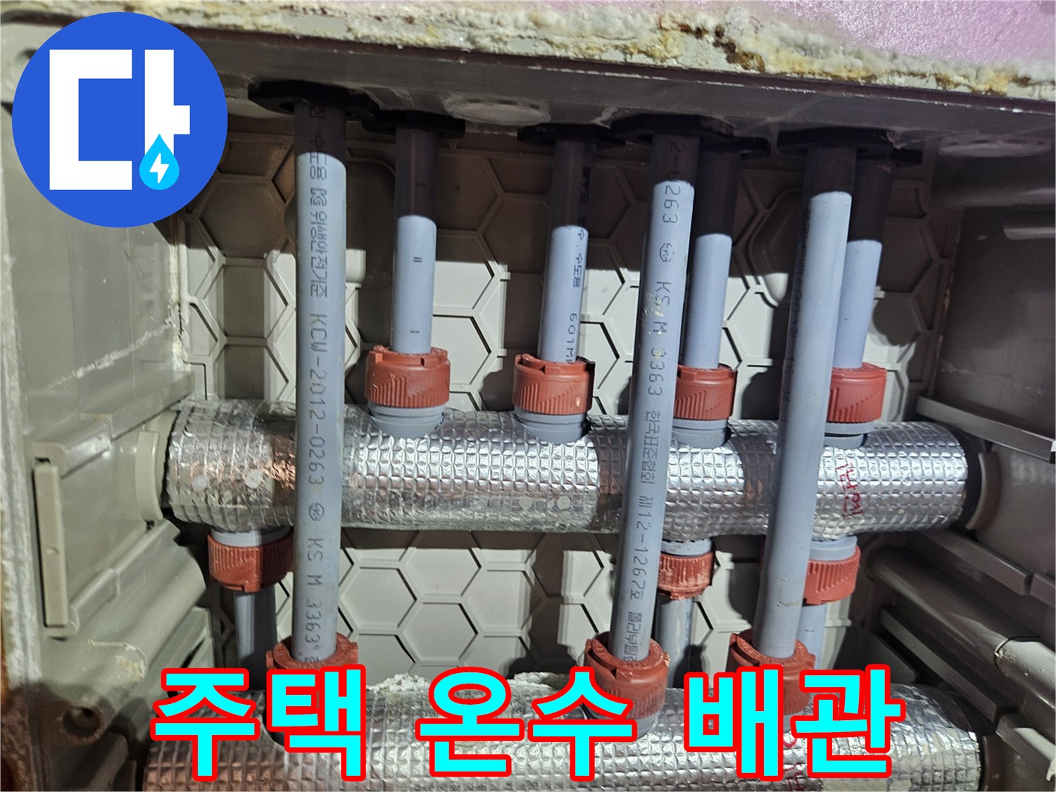 주택 온수 배관의 누수 지점을 수리하는 모습-다수의 배관과 연결부가 집중적으로 보이는 현장