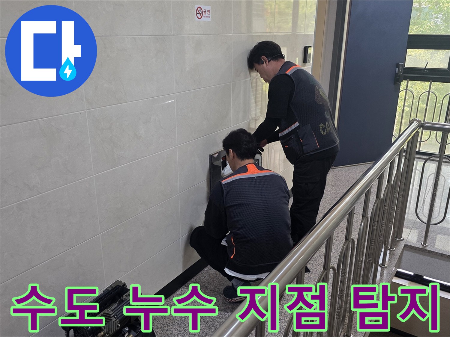 두 명의 전문 기술자가 건물 벽면 내부의 수도 누수 의심 지점을 정밀하게 탐지하고 있습니다-물 낭비 방지와 수도 요금 절감을 위한 필수 작업입니다.