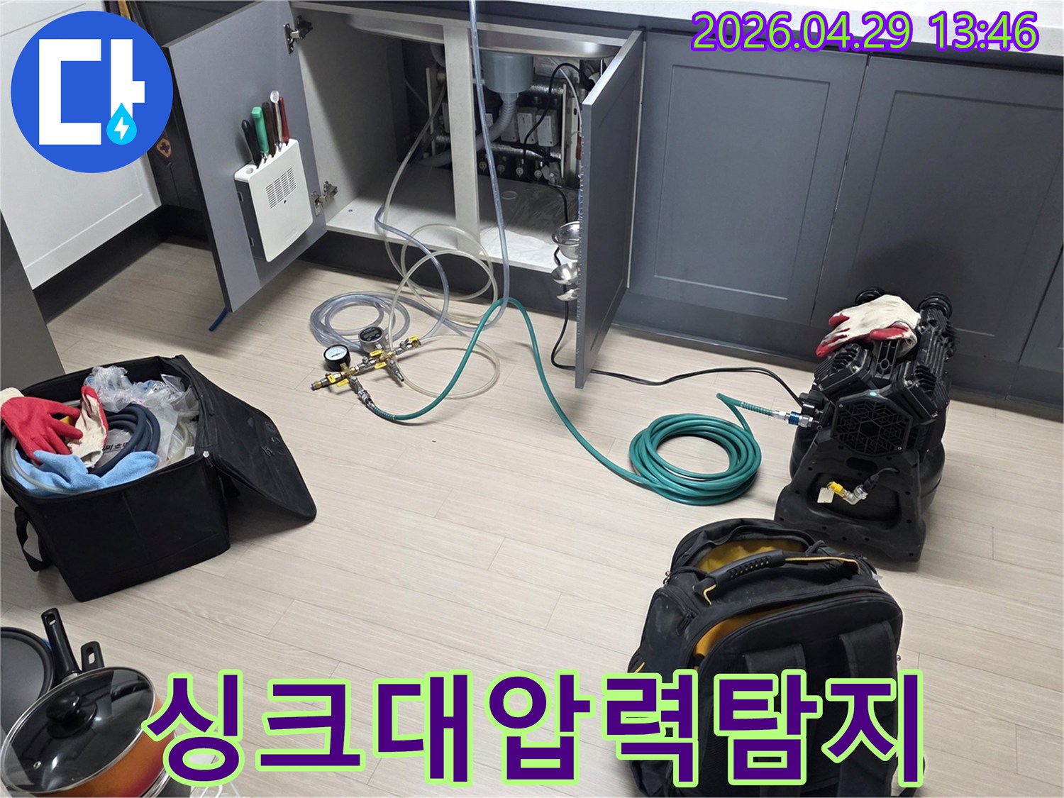 싱크대 하부장 안에서-누수 여부를 확인하기 위한-압력 게이지와 호스-그리고 공기 주입 장비가-설치되어 있는 모습입니다