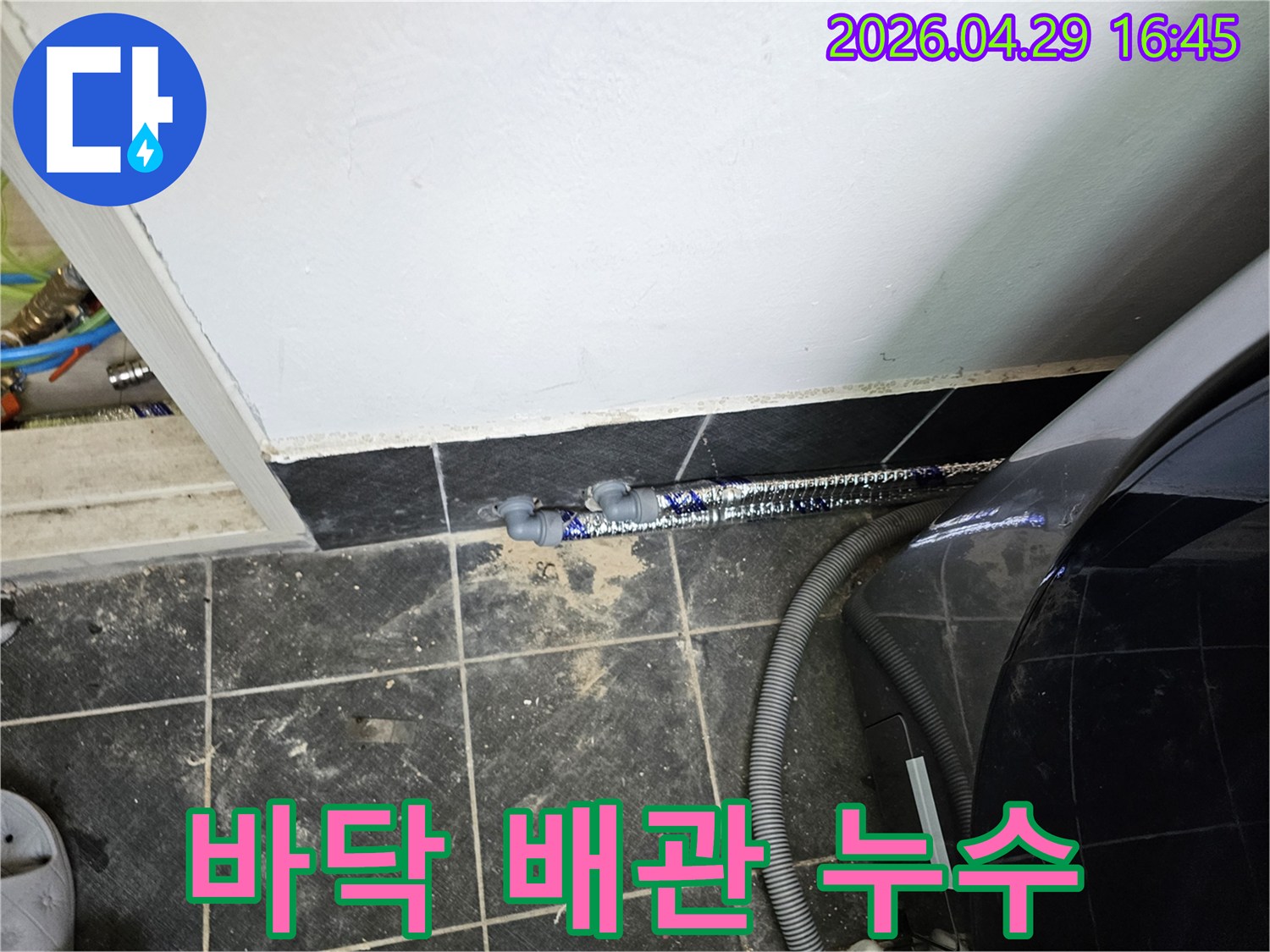세탁실-바닥에-설치된-배관에서-푸른색-염료가-새어-나와-누수를-확인시켜줍니다.