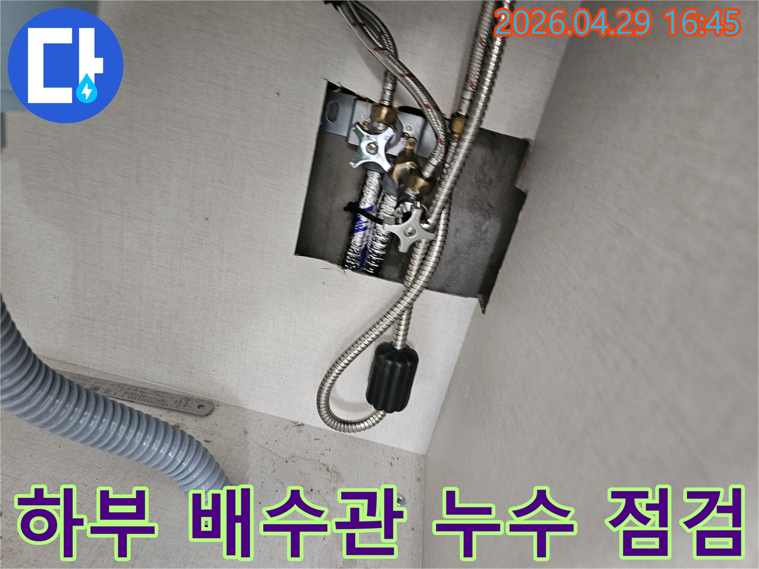 싱크대 하부의-회색 주름관으로-연결된 배수관에서-누수가 발생하는지-점검하는-전문가의-모습입니다