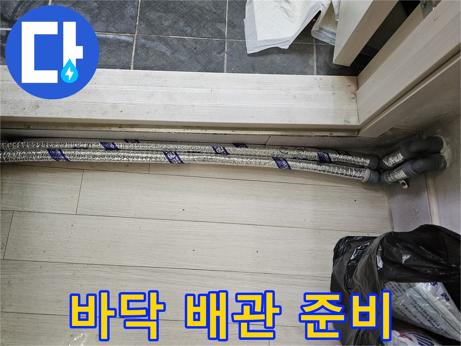 이 이미지는-남양주 진건읍 성심아트빌라-누수 배관 교체 작업을 위해-바닥 공사 전-새로운 배관 자재를-확인하는 모습을-보여줍니다