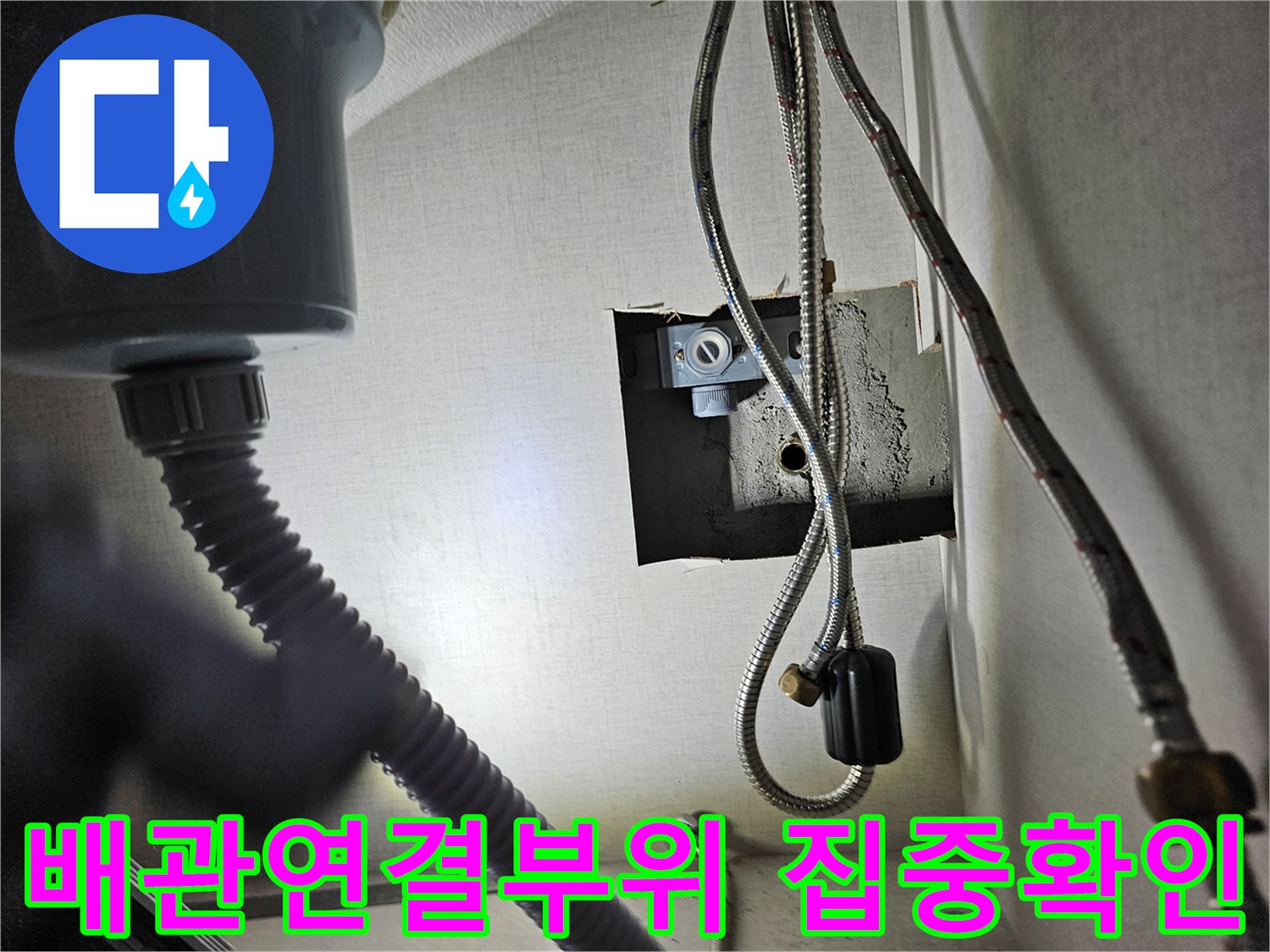 주방 싱크대 하부장 내부의-배관 연결 부위를-집중적으로 확인하여-누수 여부를-점검하는 모습입니다.