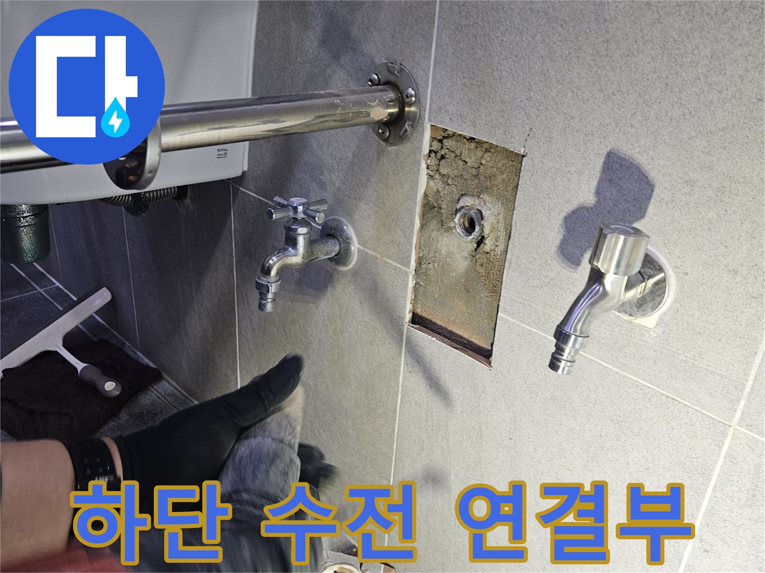 타일 제거 후 노출된 하단 수전의 연결 부위를-꼼꼼하게 점검하여 누수 원인을 찾는 모습