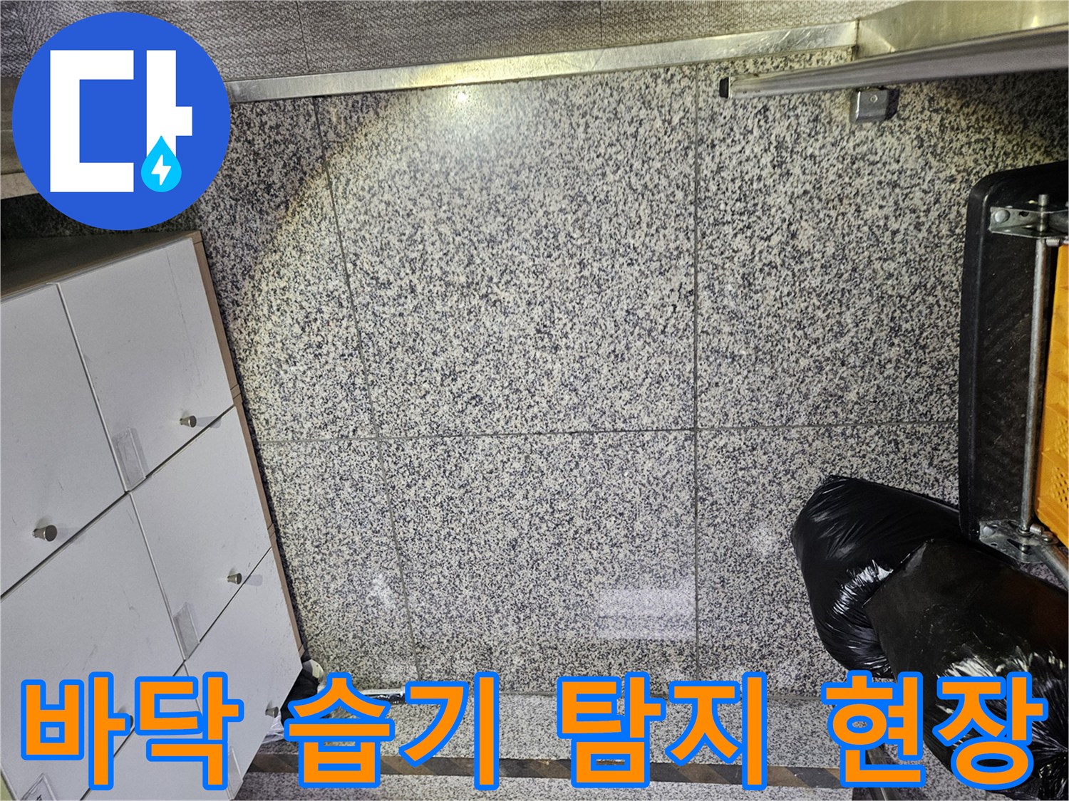 포천 상가 건물에서-바닥 타일의 젖은 부분을 발견하여-누수 전문가가 현장을 면밀히 살피는-초기 진단 단계입니다