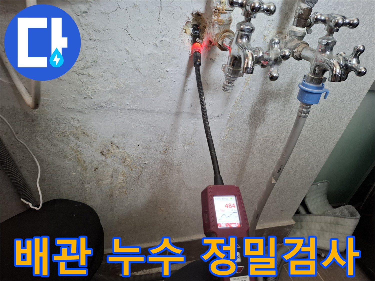 벽면 배관 근처에서 작동 중인 가스식 누수 탐지기
