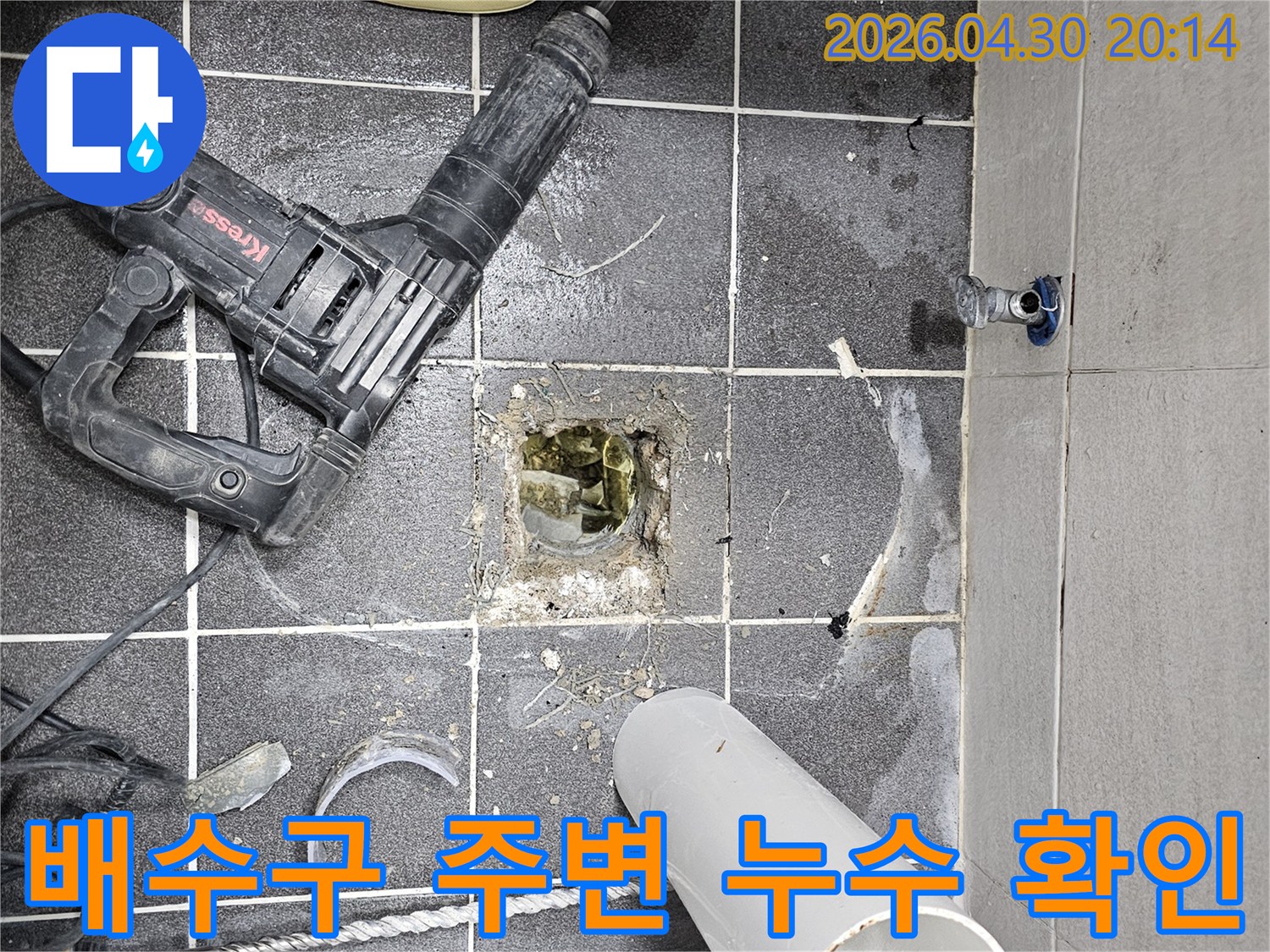 욕실 바닥의 배수구 주변에서 발생한 누수 탐지를 위해-타일을 제거하고 내부를 확인하는 작업 현장입니다.