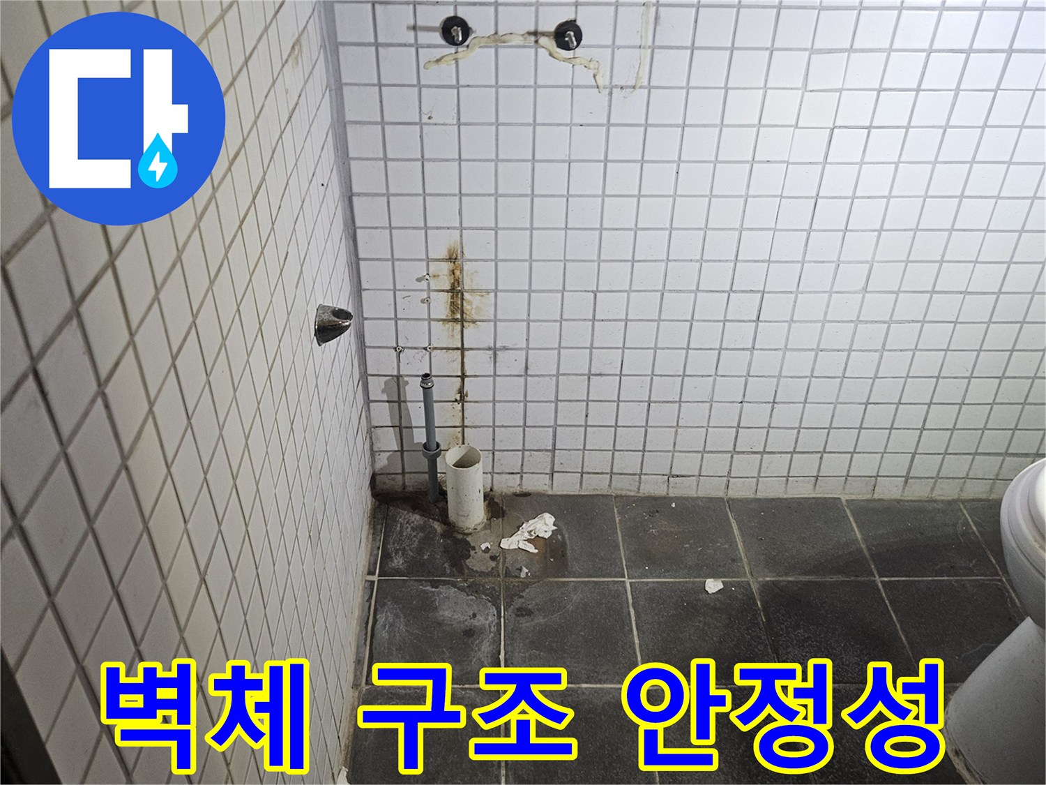 세면대 제거 후-욕실 검은색 타일 벽면에-노출된 하수 배관 주변의-벽체 손상과 구조적 안정성을-정밀하게 진단하는-누수 전문가