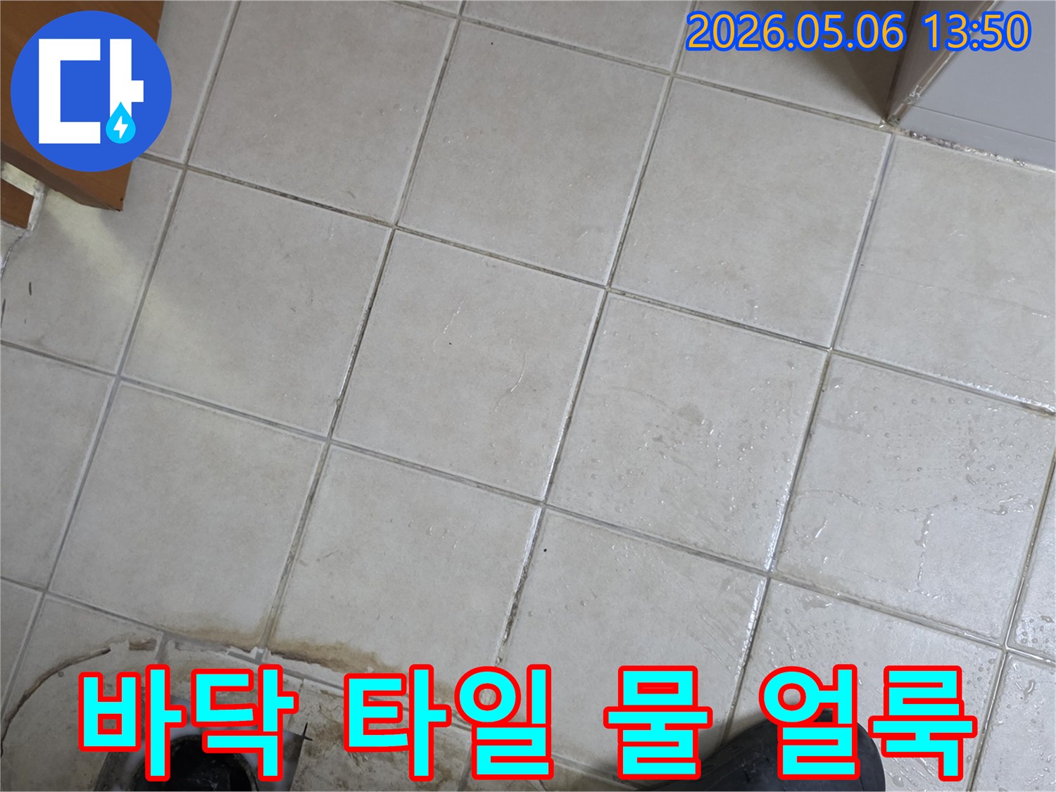 주거 공간의 타일 바닥에서-물이 스며들어 생긴-오래된 얼룩과 습기 자국을 보여주는 사진