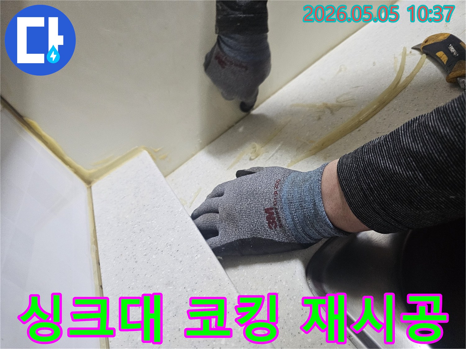 숙련된 기술자가 싱크대 주변의 오래된 실리콘을 제거하고-새로운 방수 코킹 작업을 진행하는 모습입니다