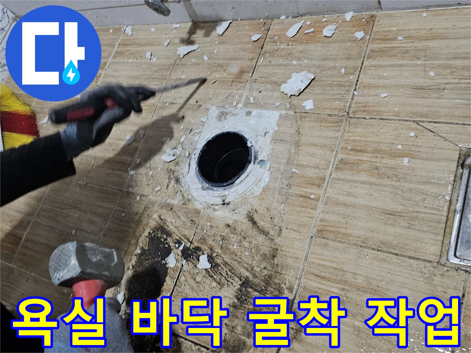 하수구 배관 주변의 타일이 제거되어 내부 구조가 드러난 현장 사진입니다.