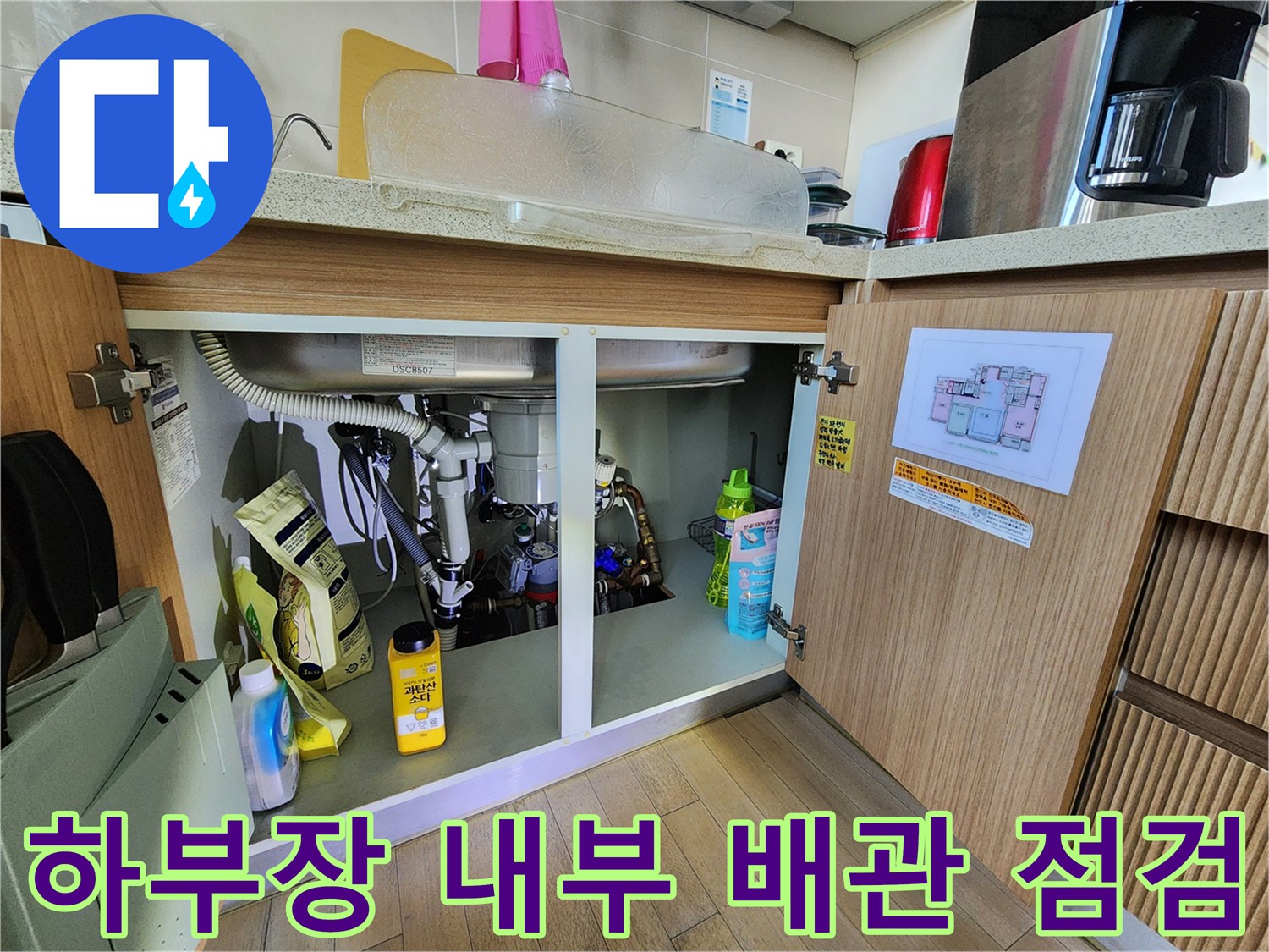 싱크대 아래쪽 배관과 주변 자재들이 보이는 점검 현장 사진