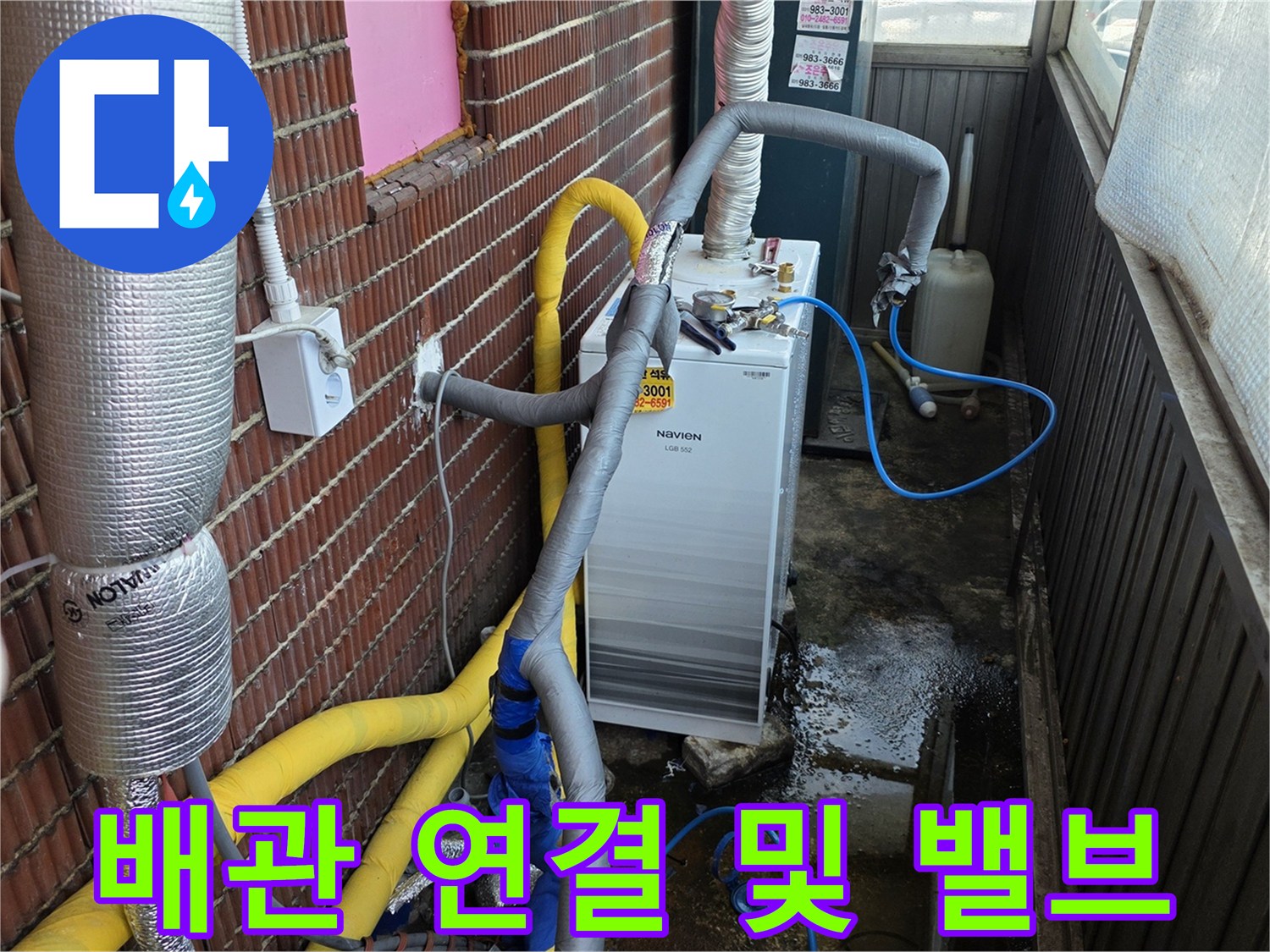 벽돌 벽면의 배관과-새로 설치된 흰색 밸브 장치 근접 촬영