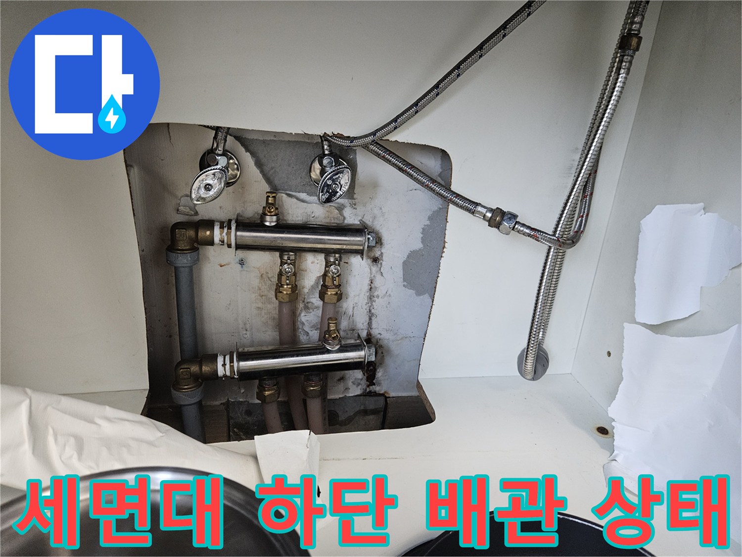 세면대 아래쪽 금속 부속과 연결된 온수 및 냉수 배관 모습