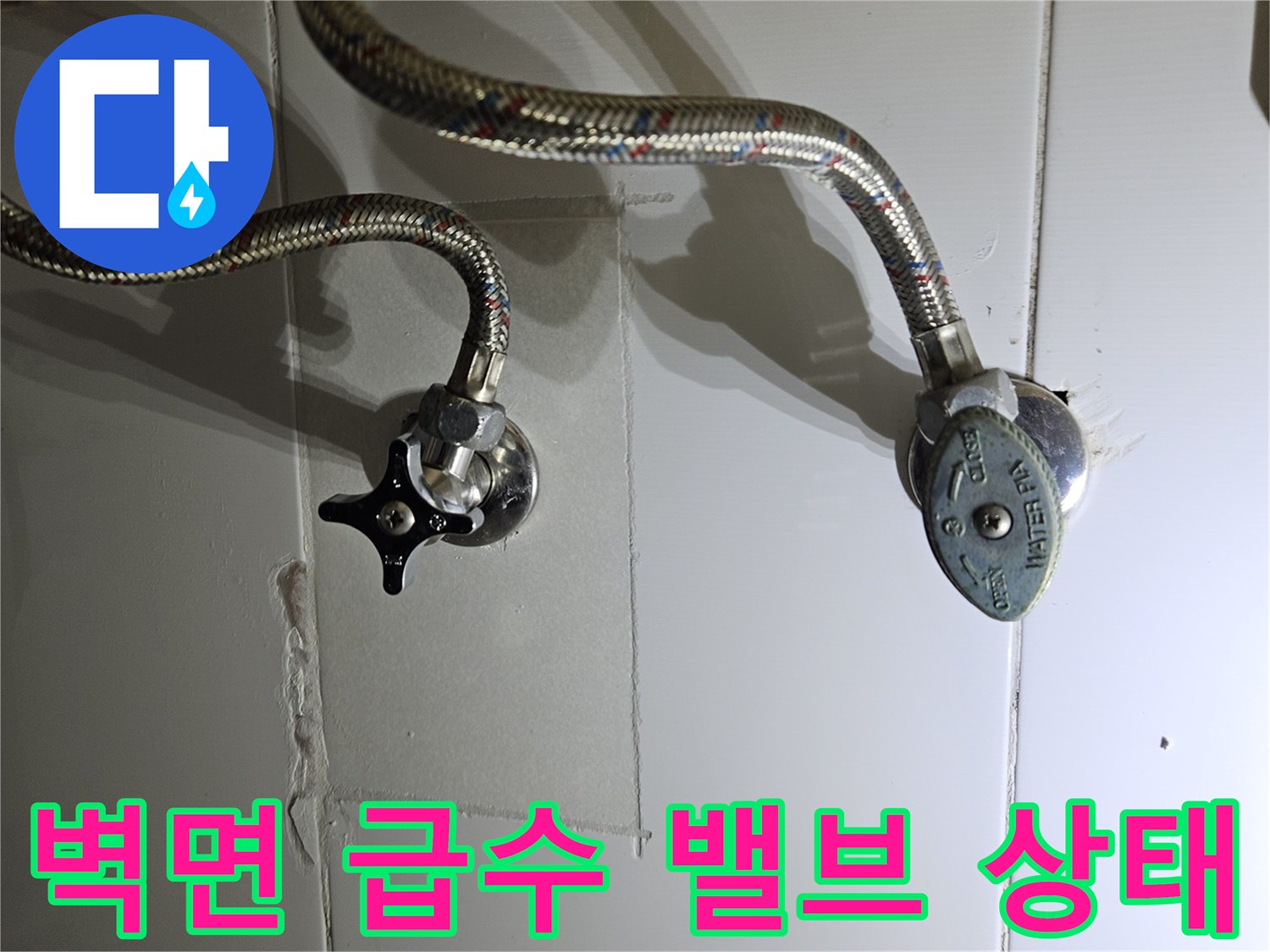 세면대 하단 벽면 수전 부속과 연결 호스 근접 촬영