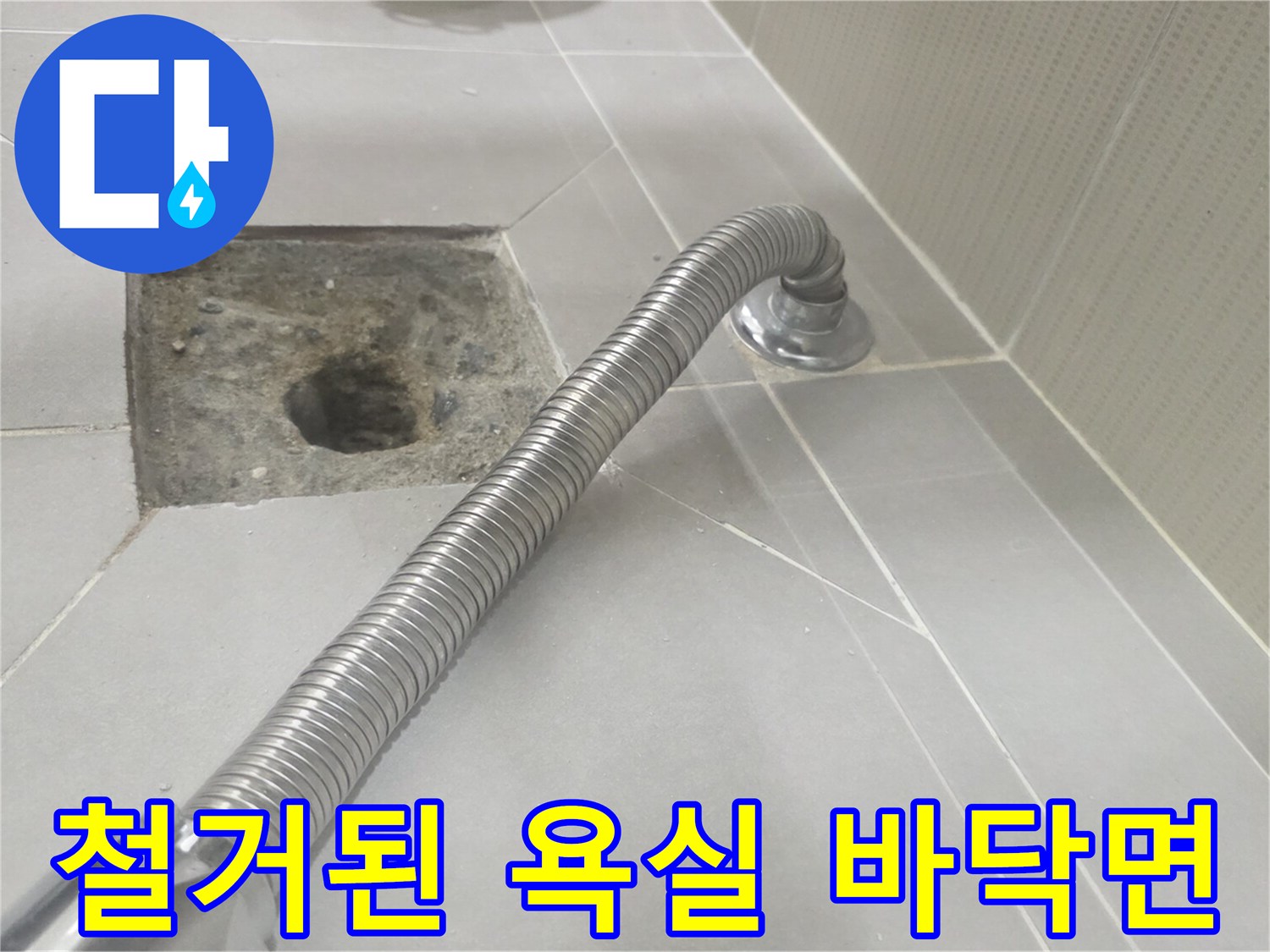배관 수리를 위해 타일을 제거하여 드러난 콘크리트와 배수구
