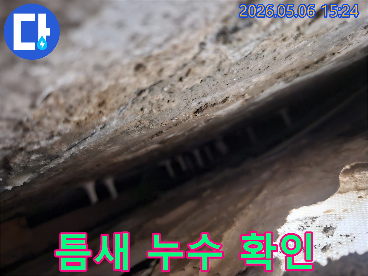 건물-틈새-안쪽에서-발견된-누수로-인한-하얀-석회질-침전물을-확대하여-보여주는-사진입니다