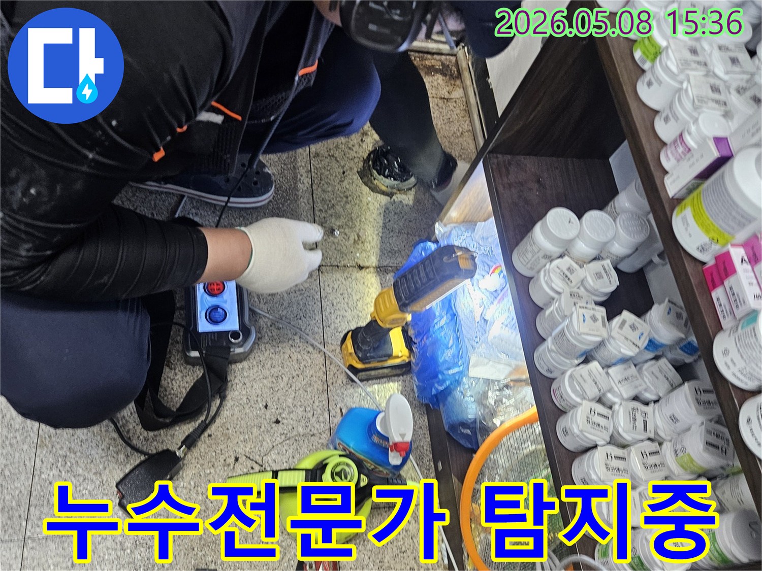 숙련된 엔지니어가-싱크대 하부의-미세한 배관 누수음을-정밀 청음 탐지기로 찾아내는 장면