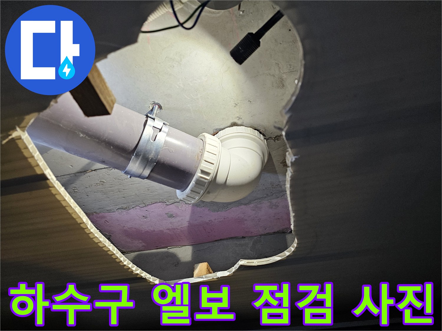 천장 내부 노출된 하수 배관의 연결 부위와 클램프 체결 상태입니다.