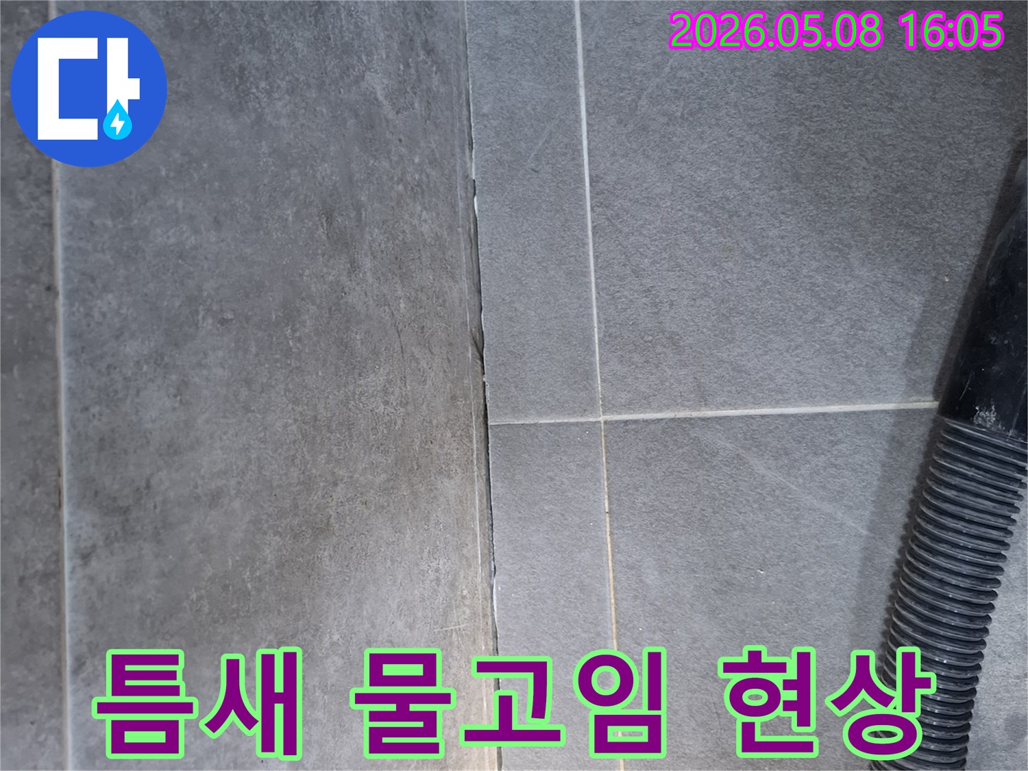 이 이미지는 아파트-베란다-타일-틈새에서-발견된-물고임-현상을-보여주며-누수-원인-파악을-위한-현장-조사-자료입니다.